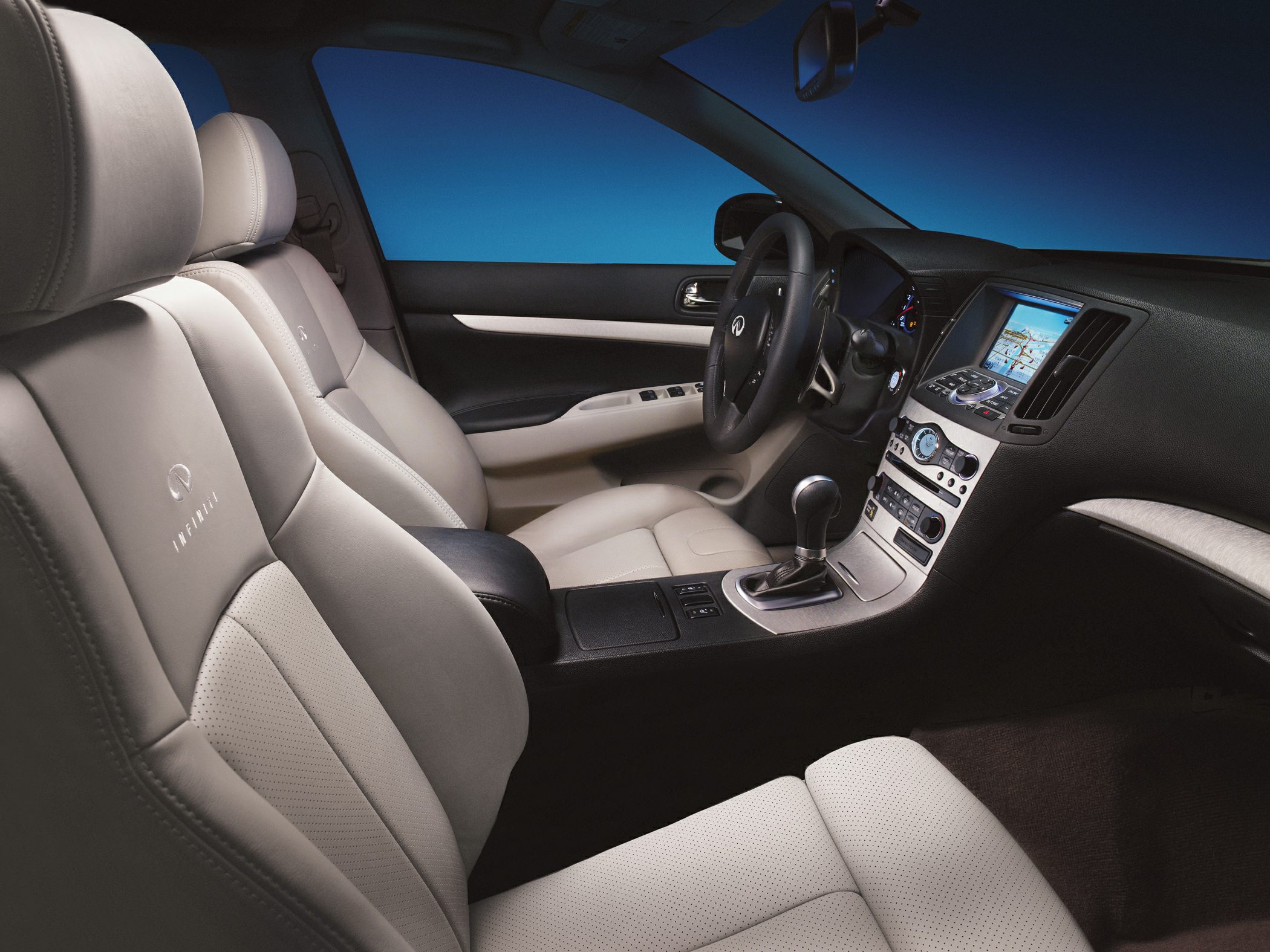 Beige leather seats with Infiniti logo and modern dashboard with navigation.