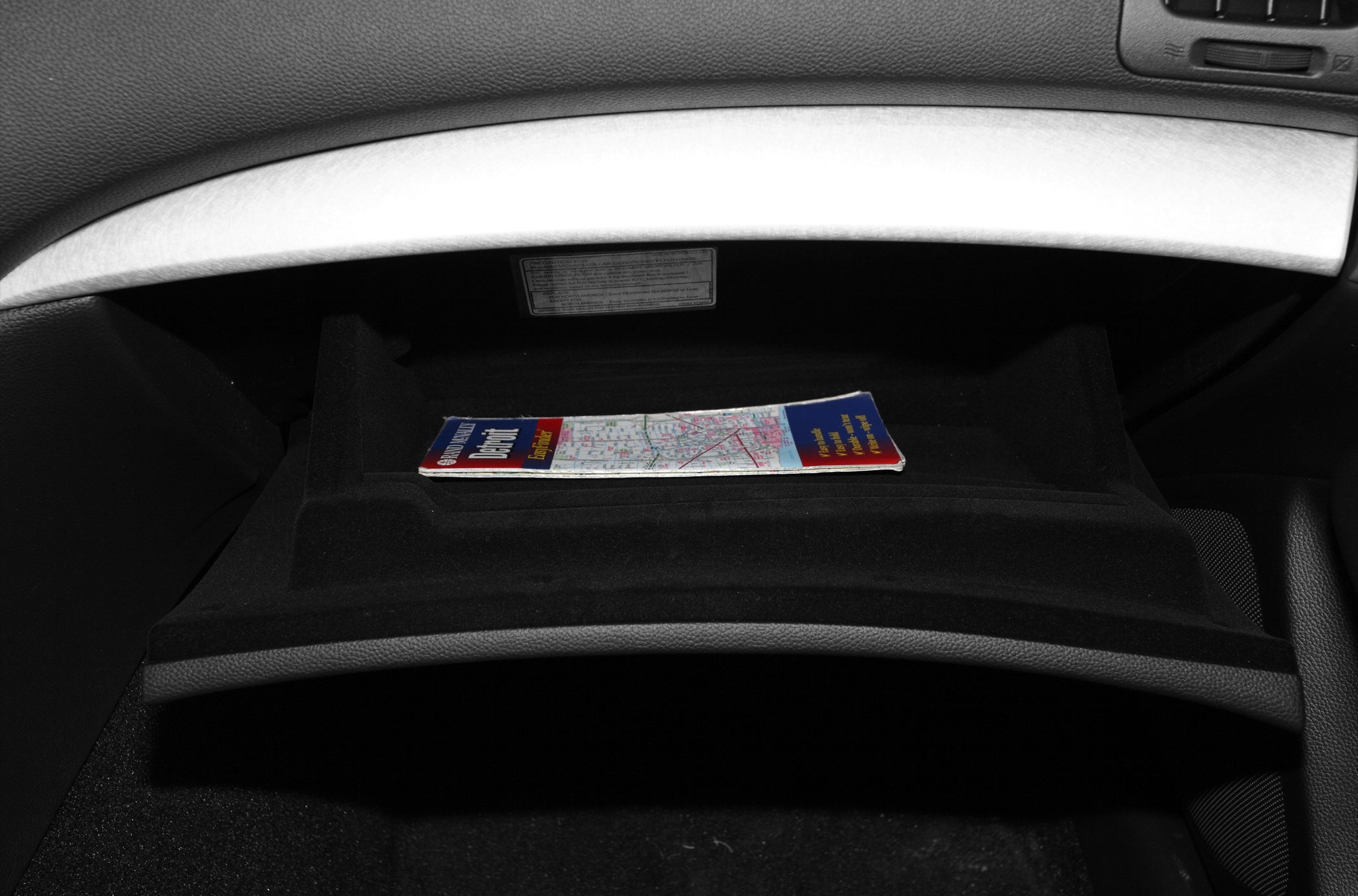 Open glove compartment showing folded map inside