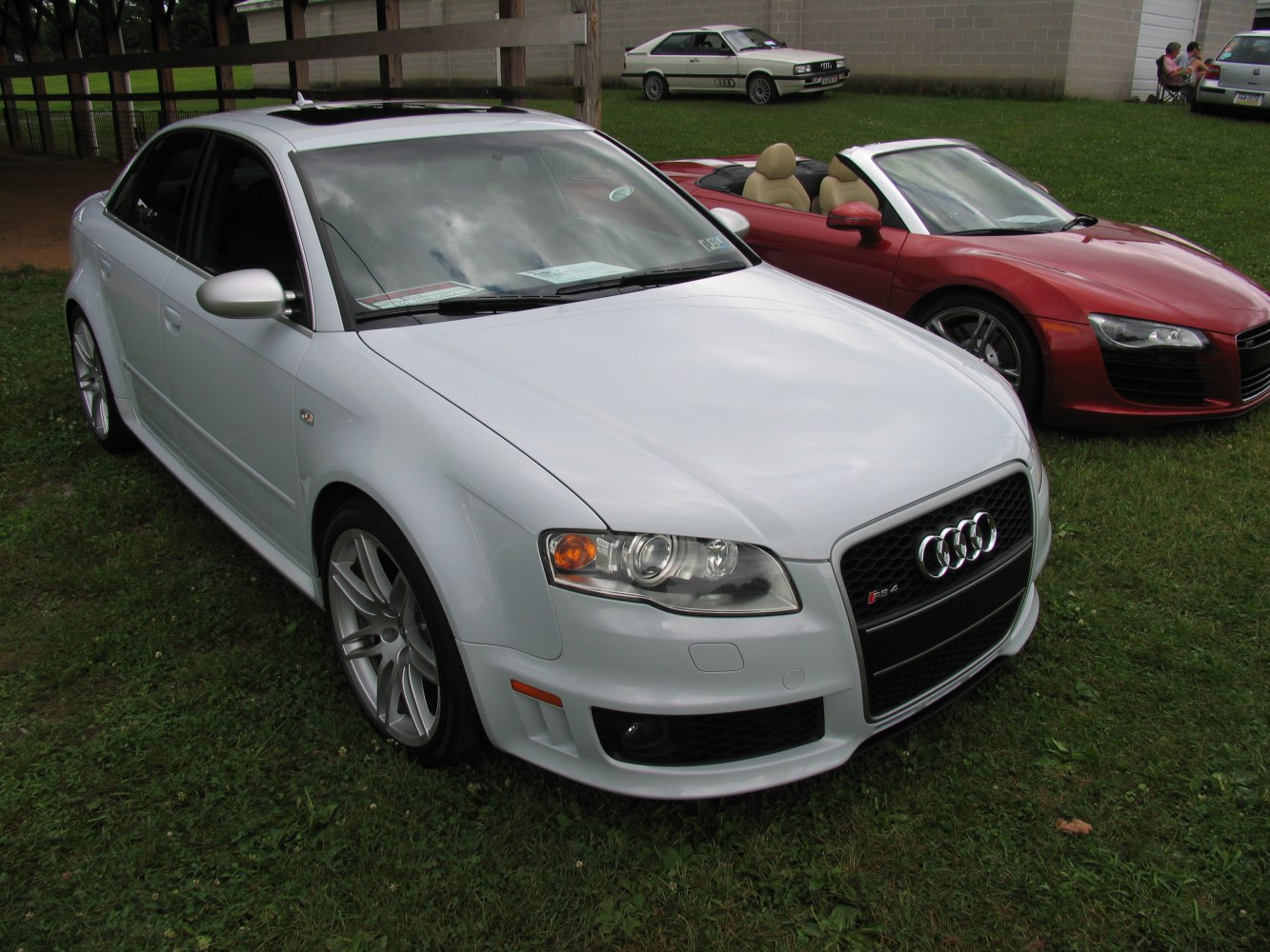 Front view of a white sedan with distinctive headlights and alloy wheels