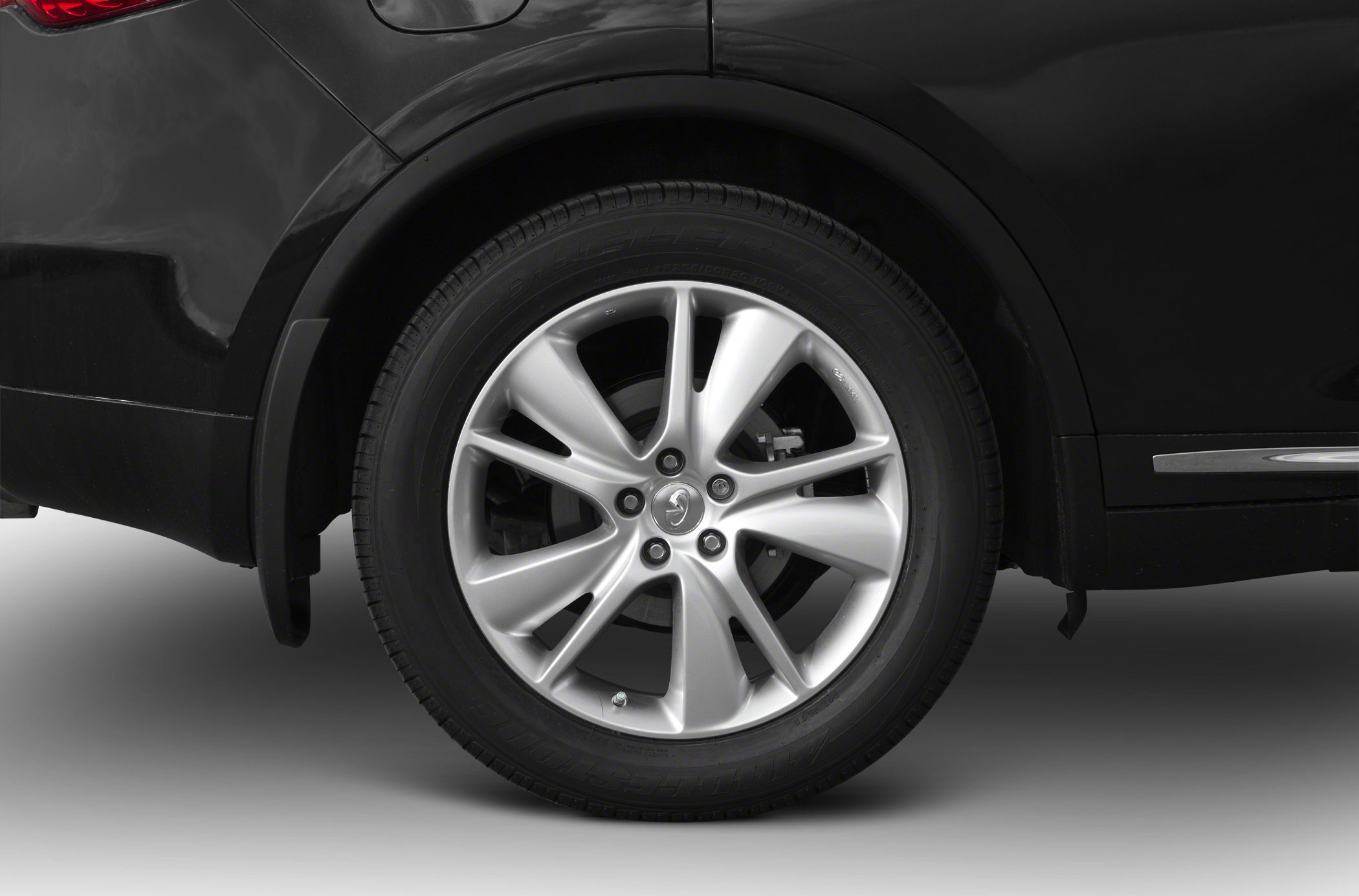 Close-up of alloy wheel and tire on a black vehicle's rear side