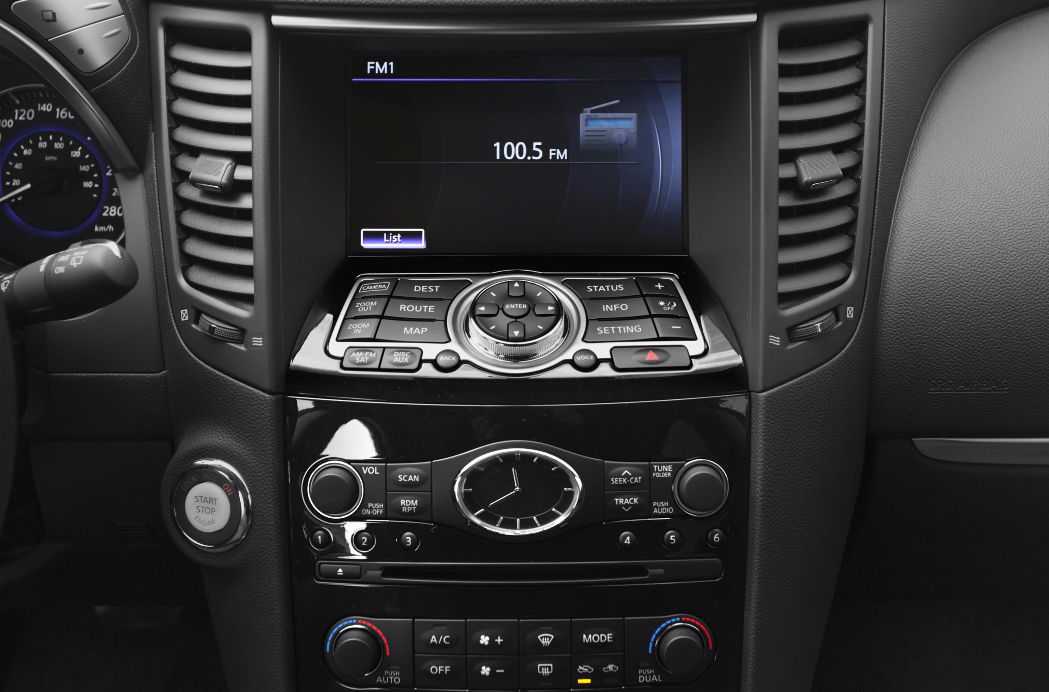 Car center console with infotainment screen, analog clock, and climate controls