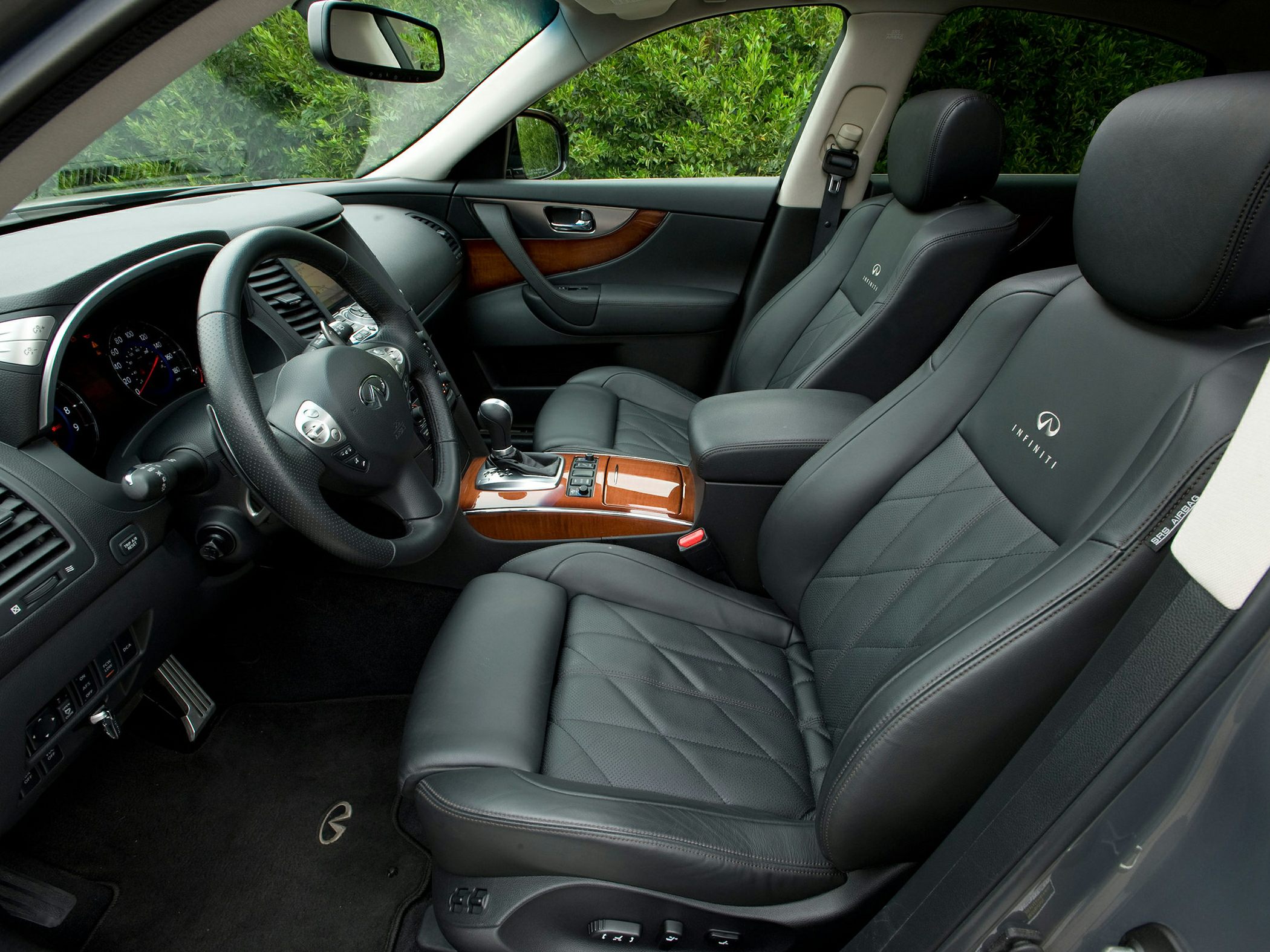 Luxurious black leather interior with wood trim and Infiniti branding