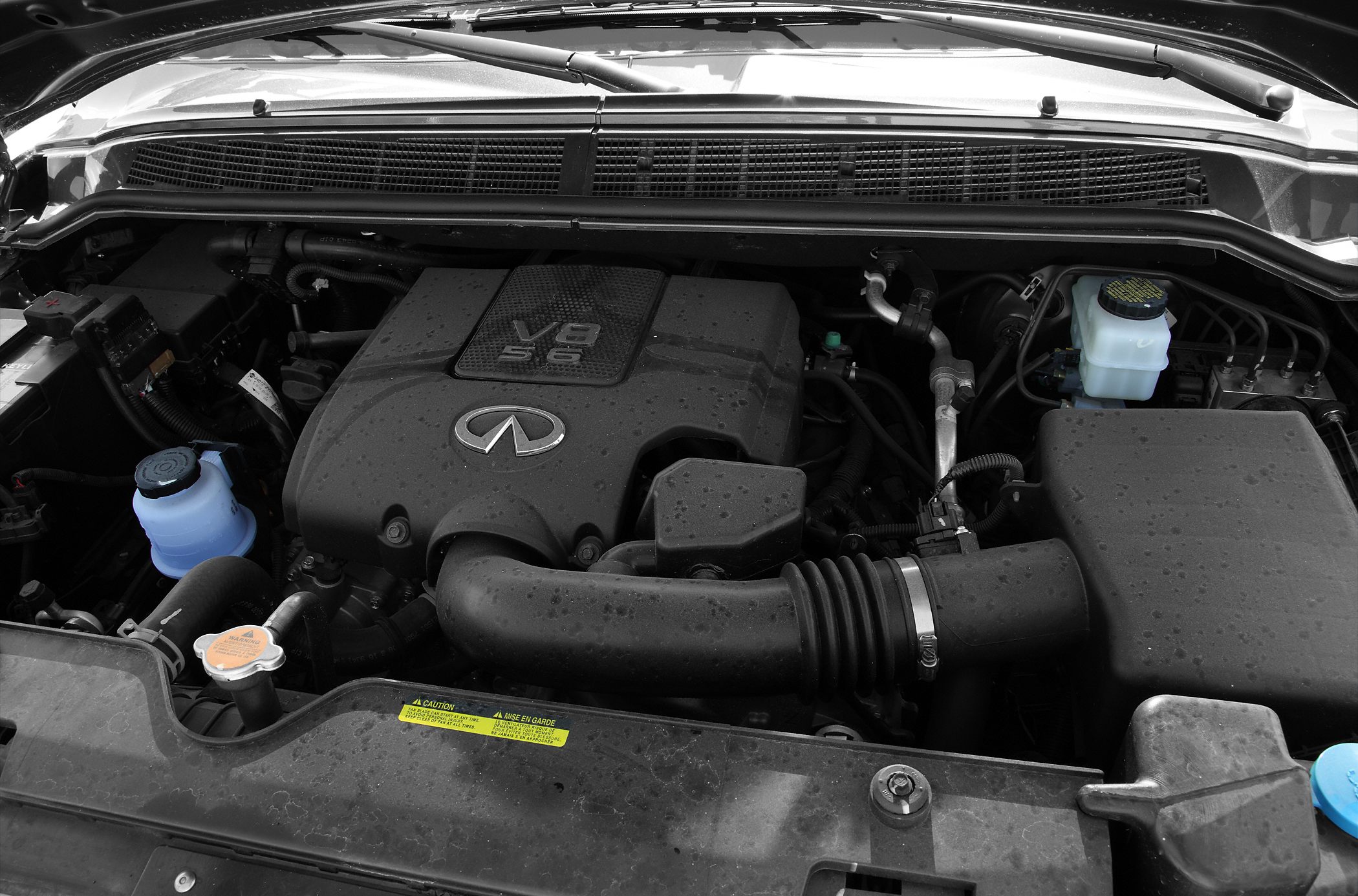 Close-up of a V8 5.6L engine with labeled cover and engine bay components
