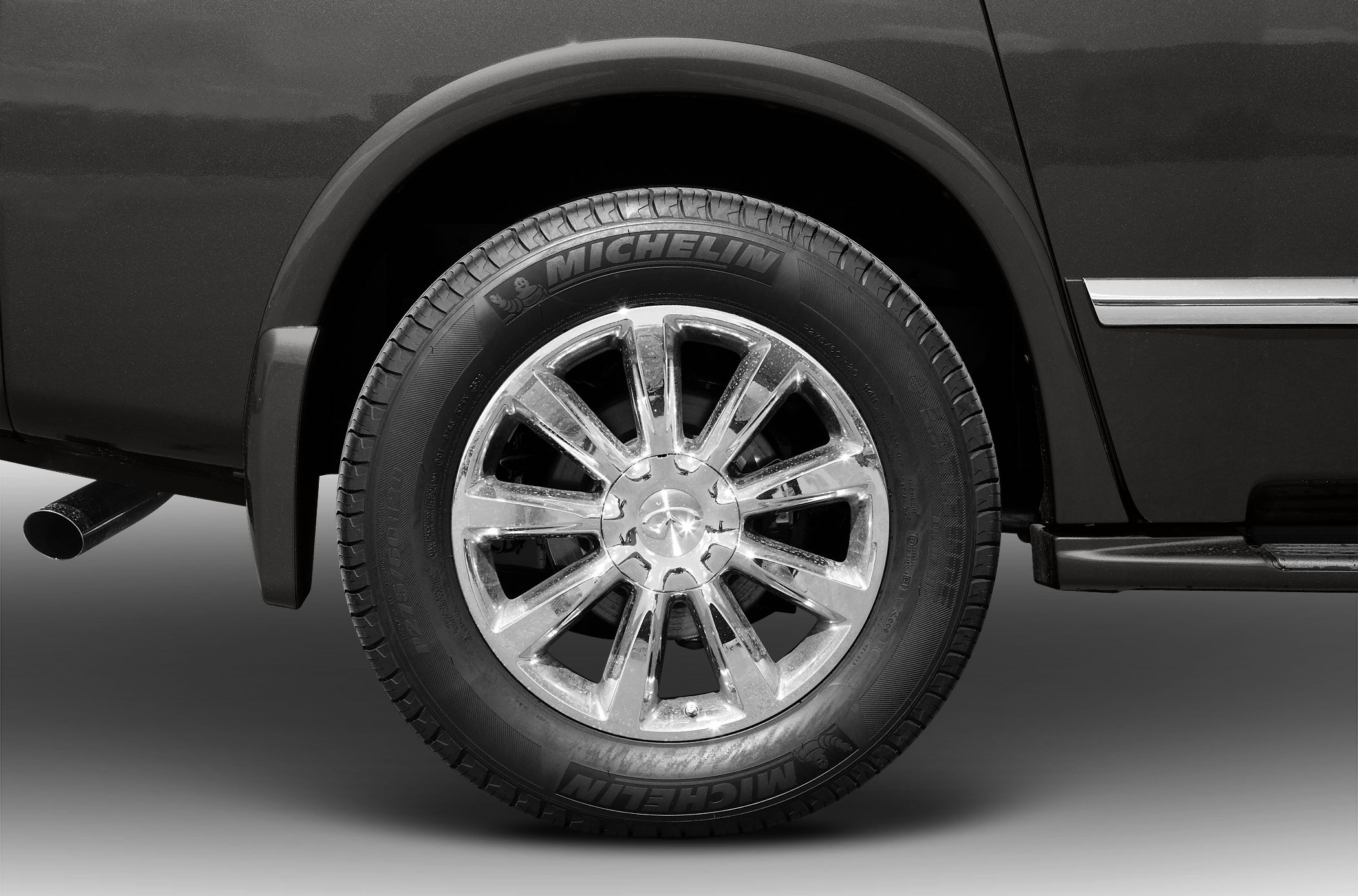 Chrome alloy wheel with Michelin tire on SUV.