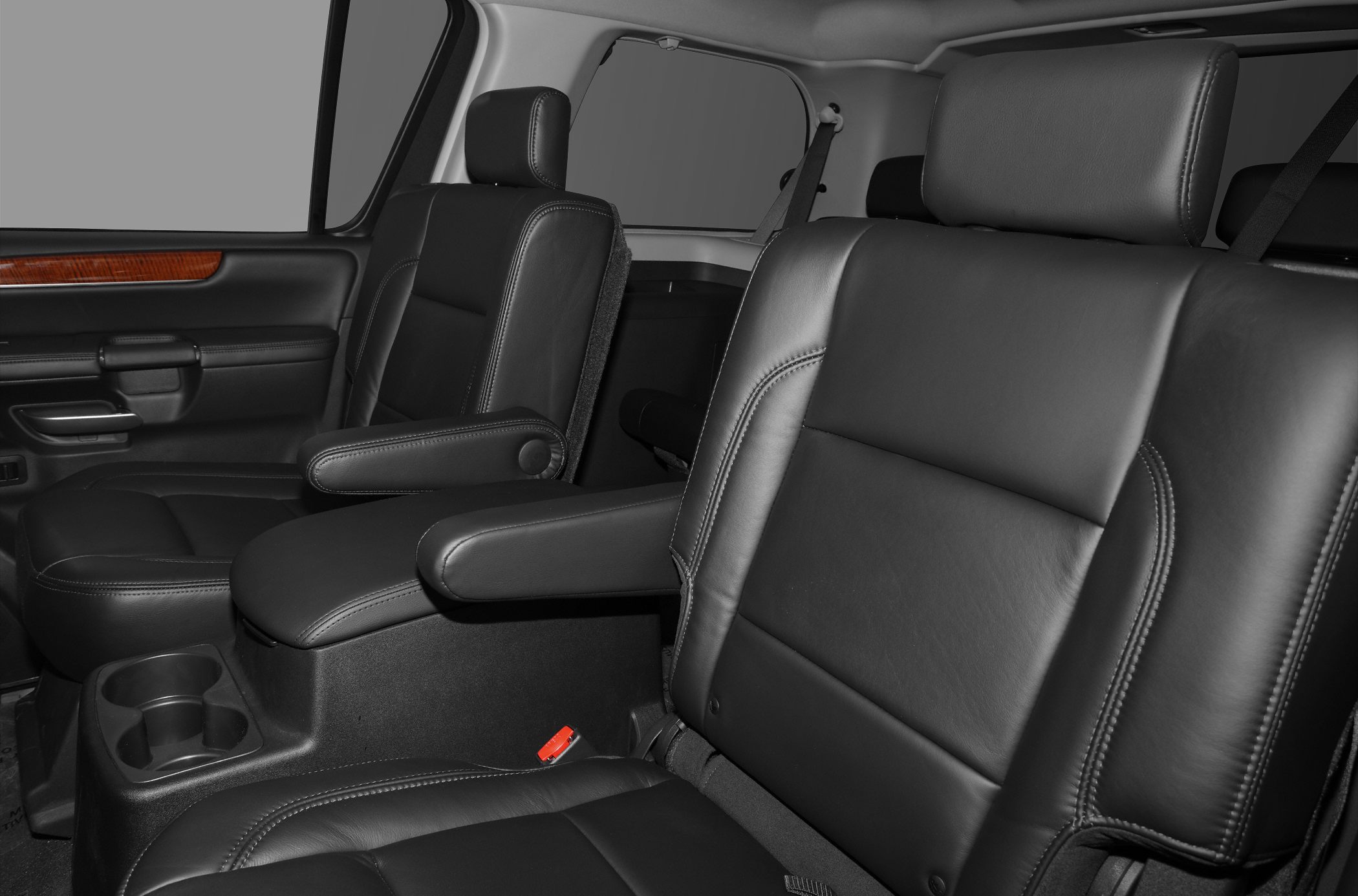 Black leather car seats with armrests and cup holders