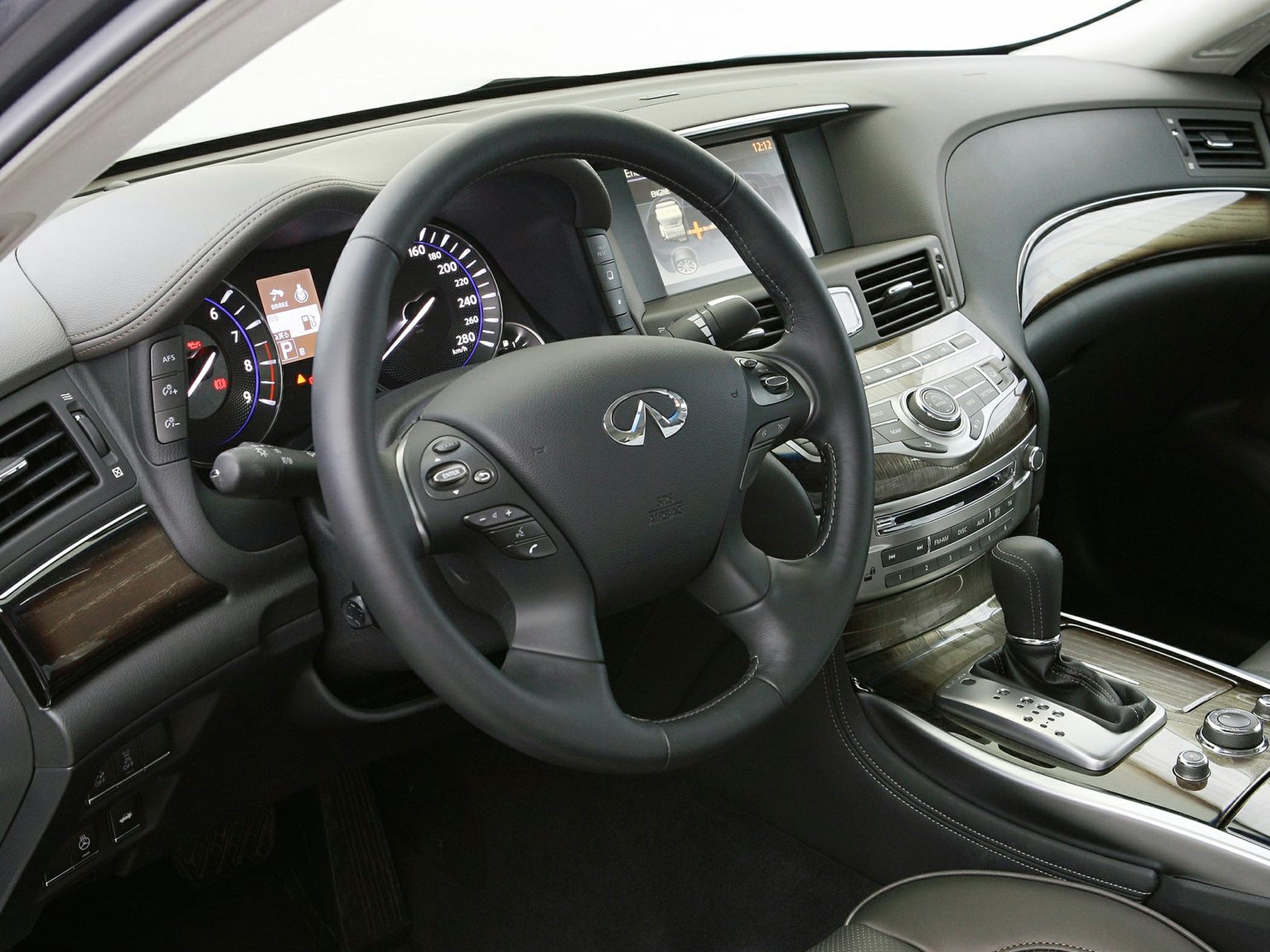 Steering wheel, instrument cluster, and wood-trimmed center console with gear shifter