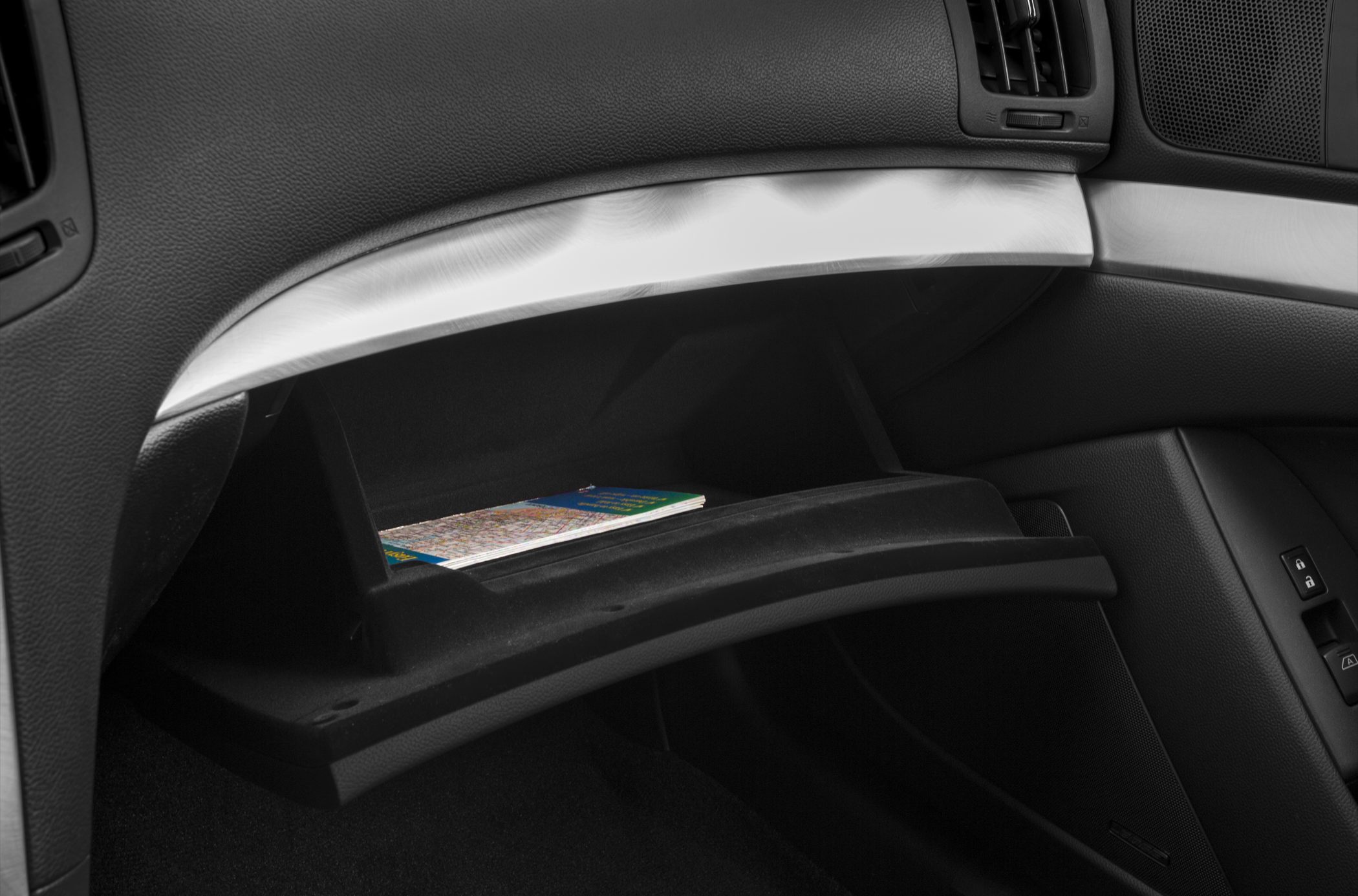 Open glove box interior with map inside and surrounding dashboard trim detail.