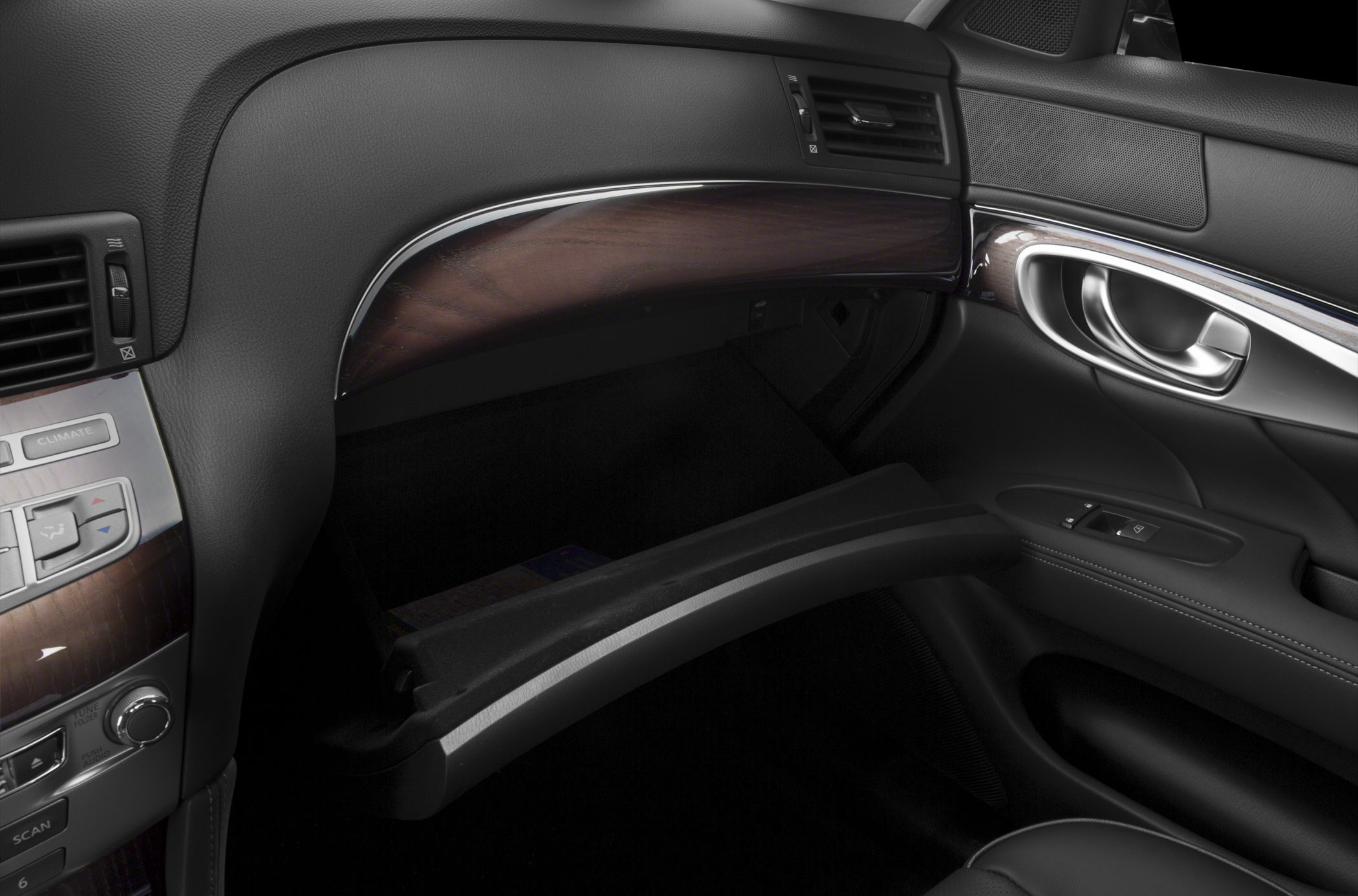 Open glovebox with wood trim and door handle in car interior