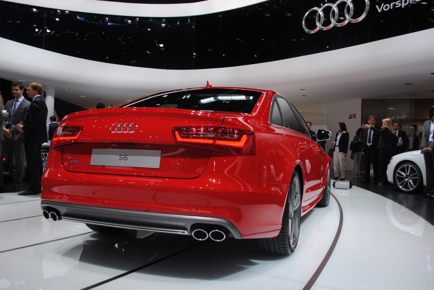 Sporty rear view of a red sedan with quad exhaust and LED taillights