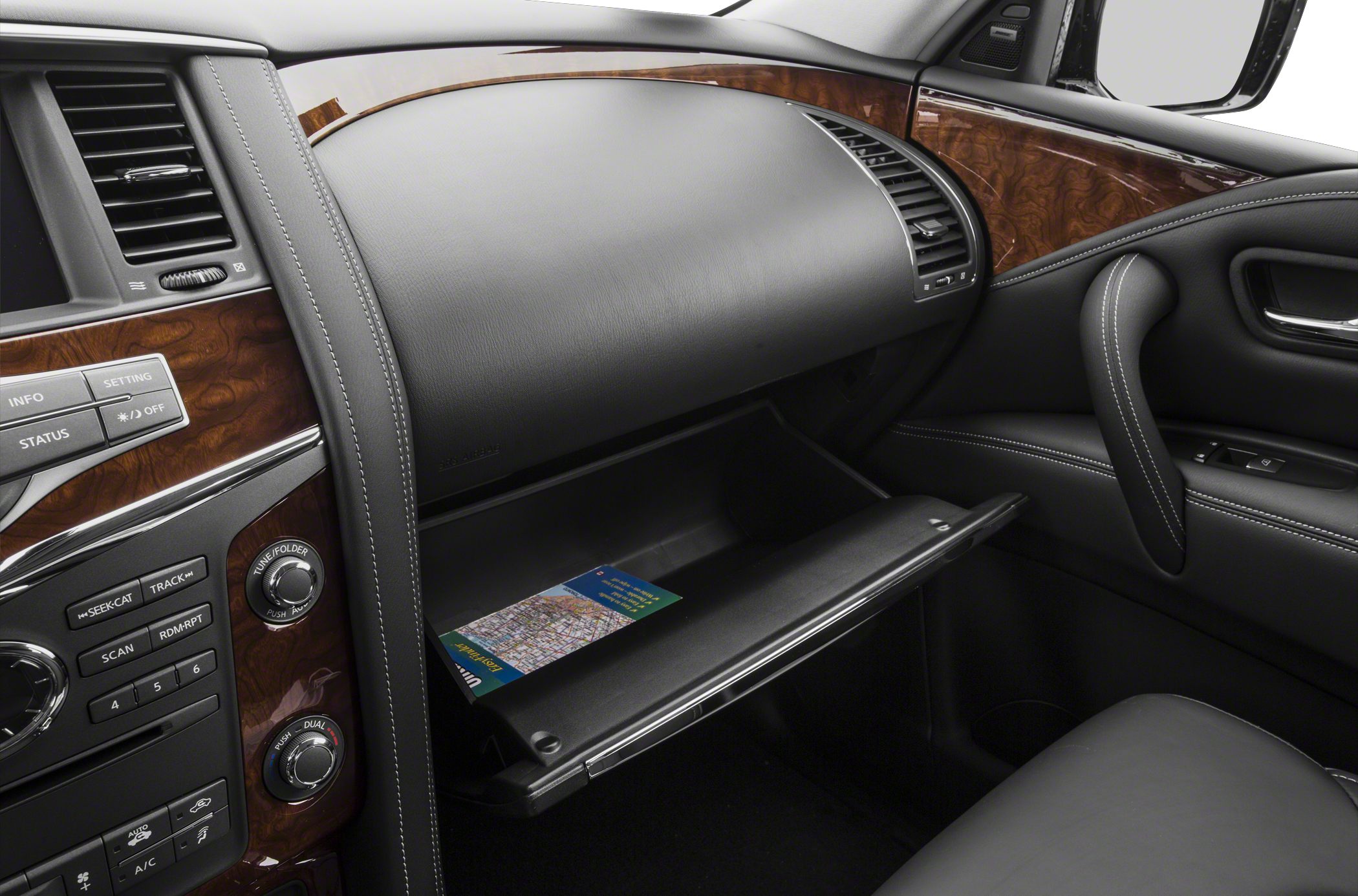 Dashboard with wood trim, controls, and open glove compartment.