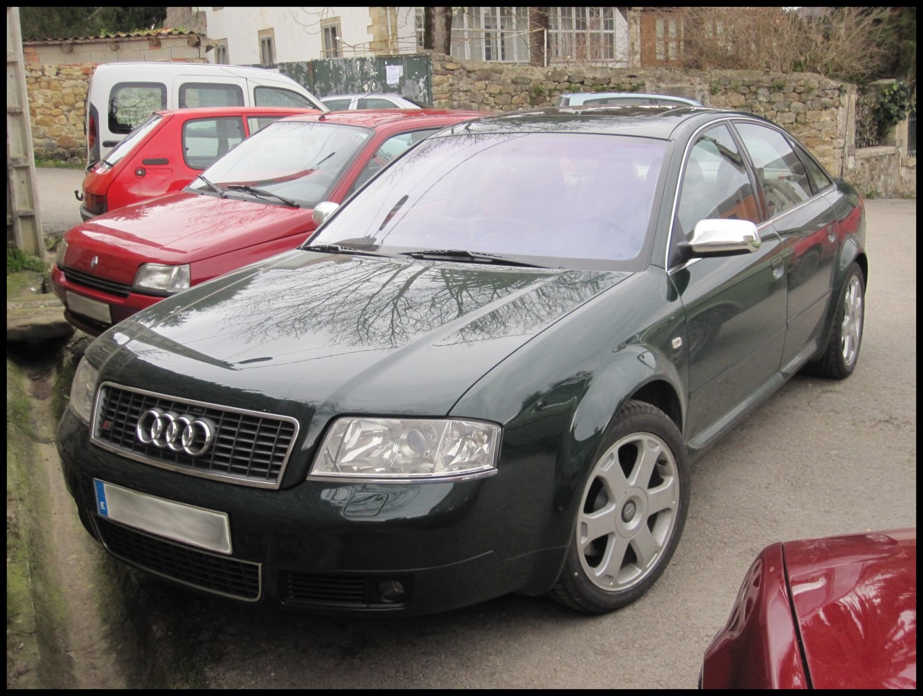 Audi-style alloy wheels and chrome side mirrors on a sporty sedan front angle