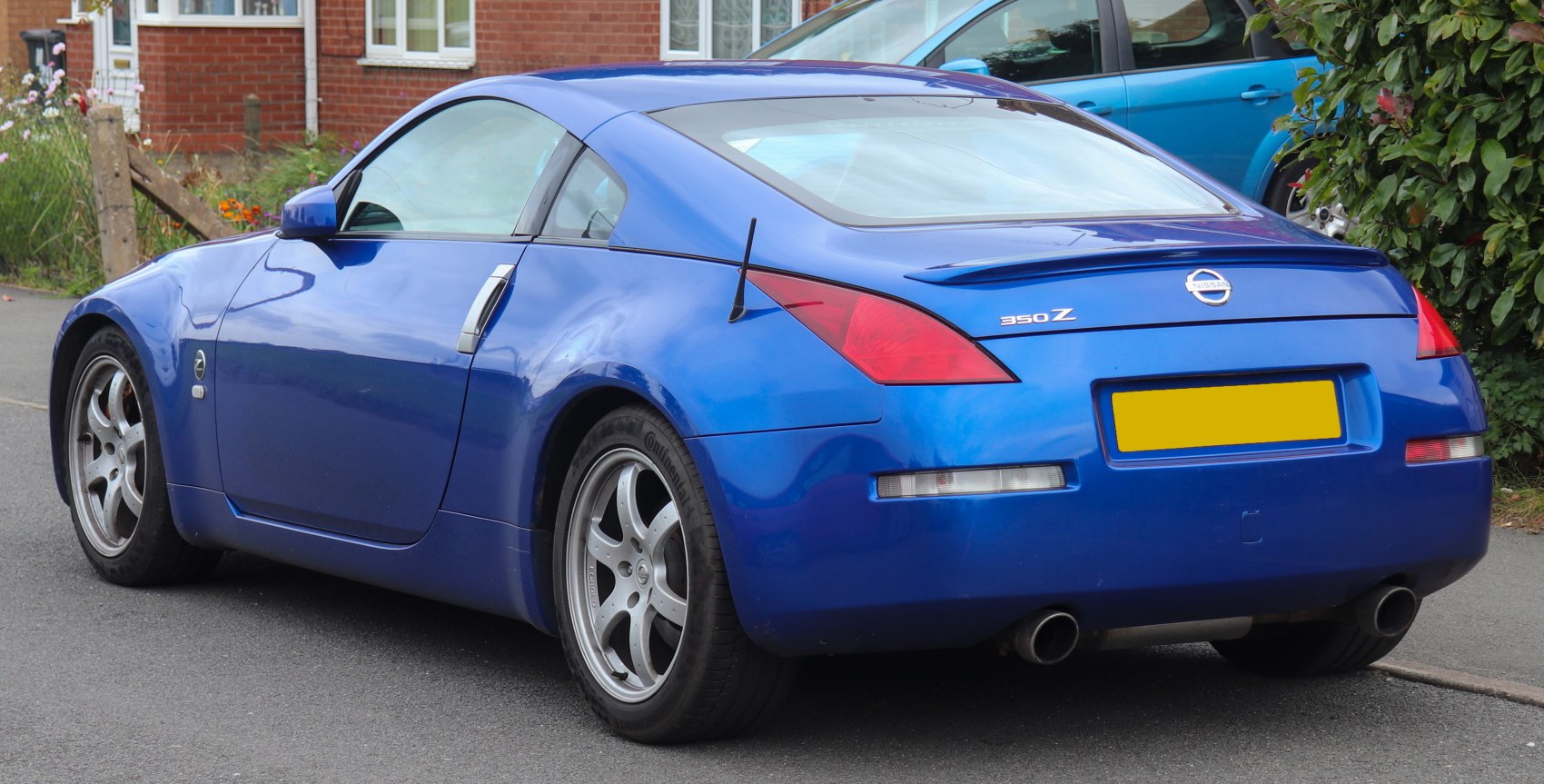 Rear and side view of blue coupe with dual exhaust and distinct taillights