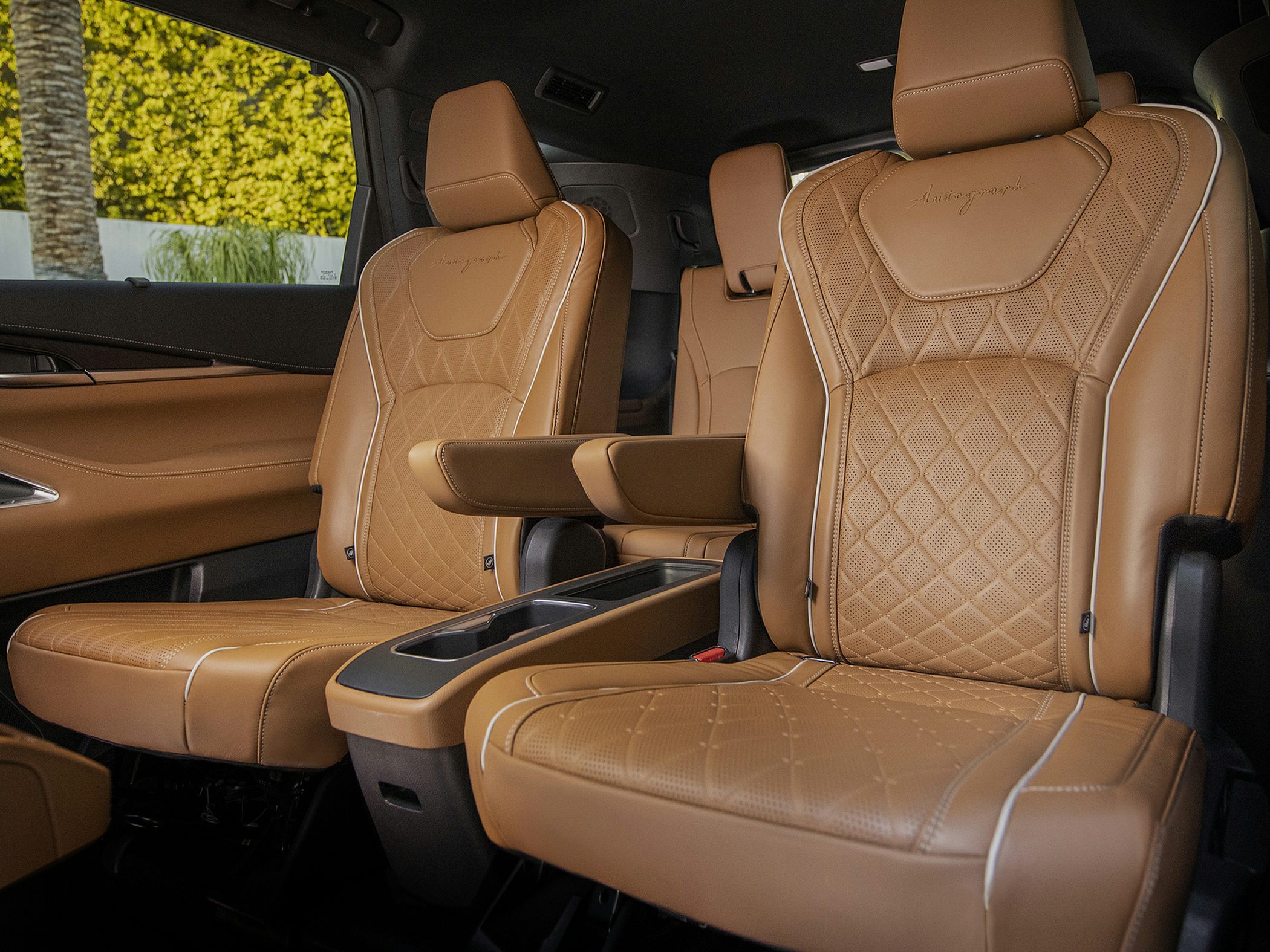 Brown leather captain's chairs with quilted pattern and armrests