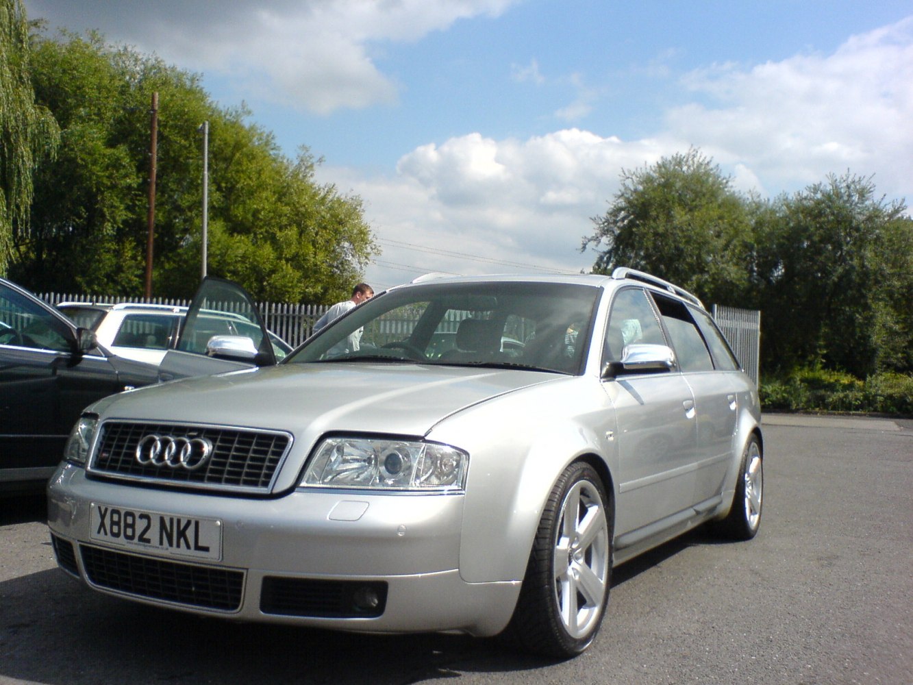 Silver wagon with alloy wheels and roof rails front-side view