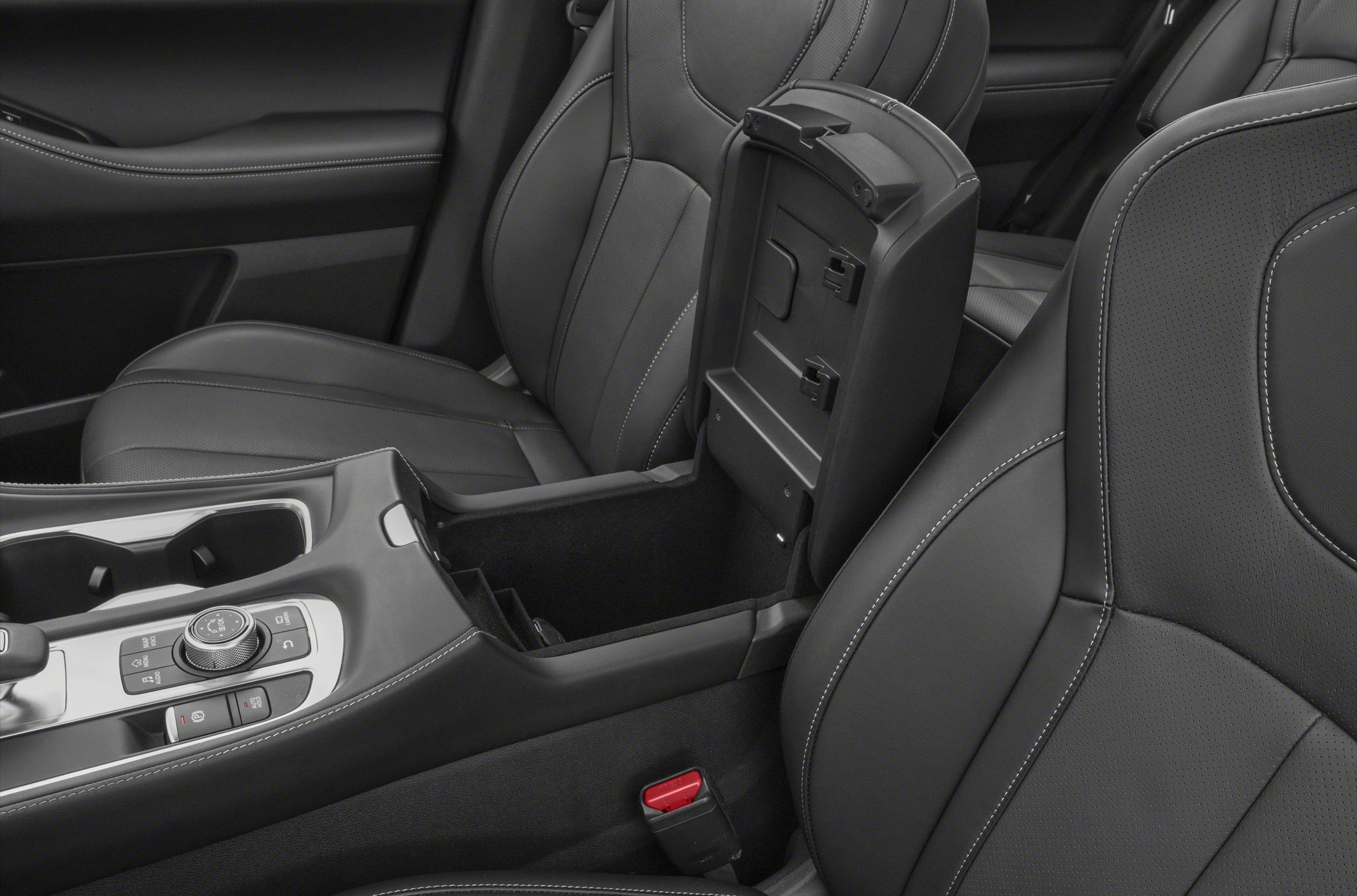 Leather seats and center console with storage compartment and control buttons.
