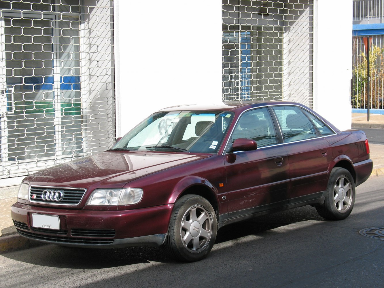 Side profile of a mid-90s four-door sporty sedan with alloy wheels.