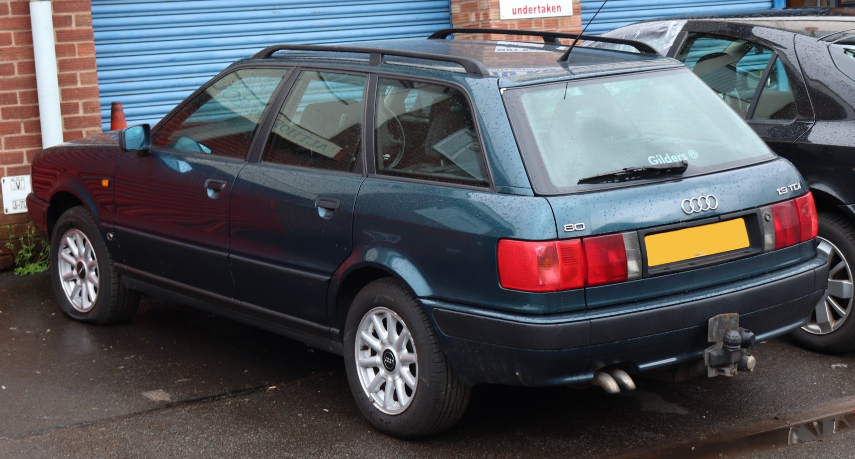 Station wagon rear-side view with roof rails and dual exhaust pipes