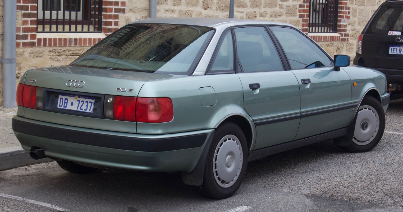 Rear three-quarter view of a sedan with classic 90s tail lights and smooth body lines