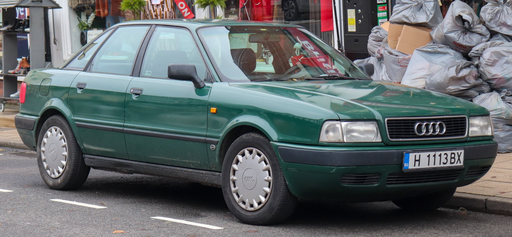 Green four-door sedan with distinct 1990s design and Audi hubcaps