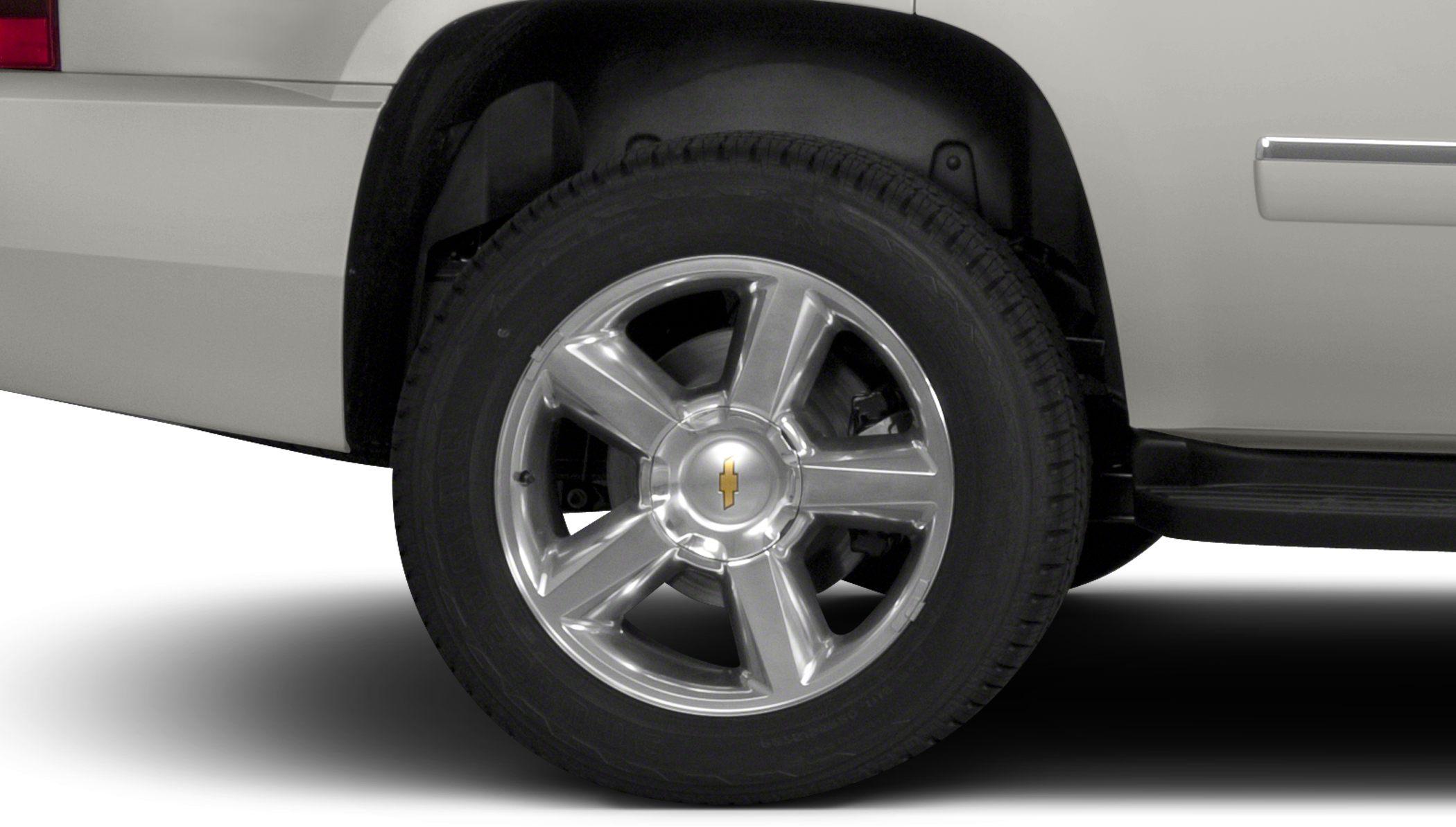 Five-spoke chrome wheel and tire with visible suspension and wheel well