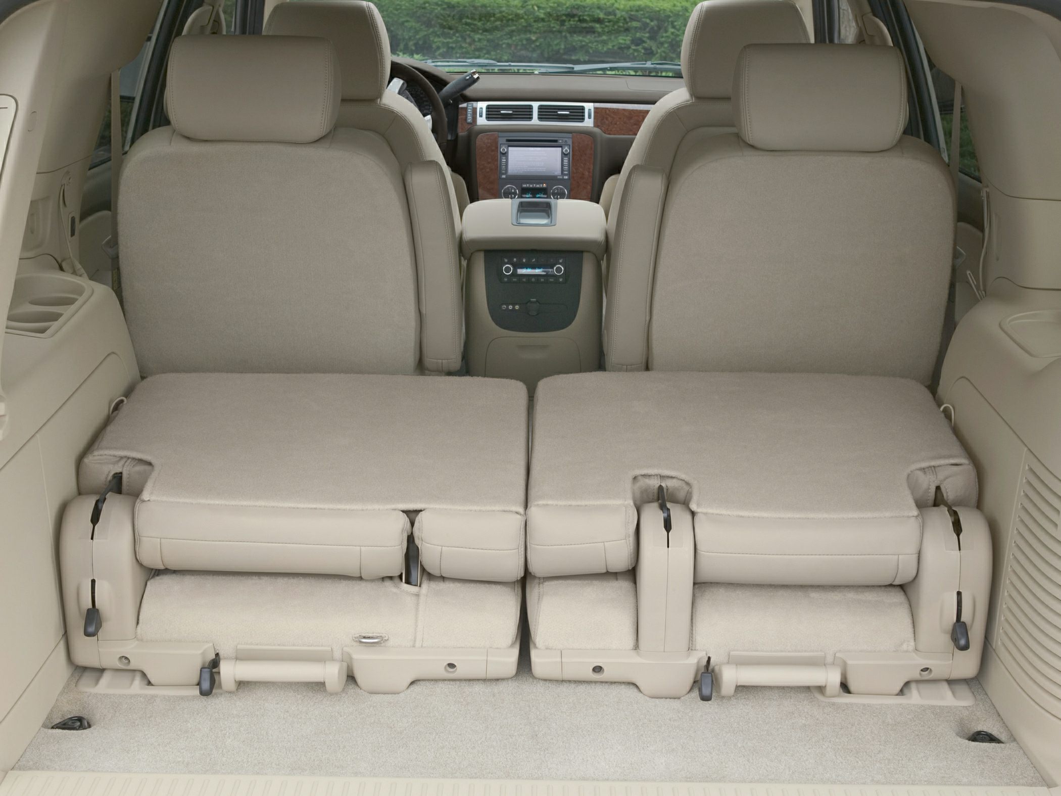 Beige rear seats folded flat to expand cargo space in SUV interior
