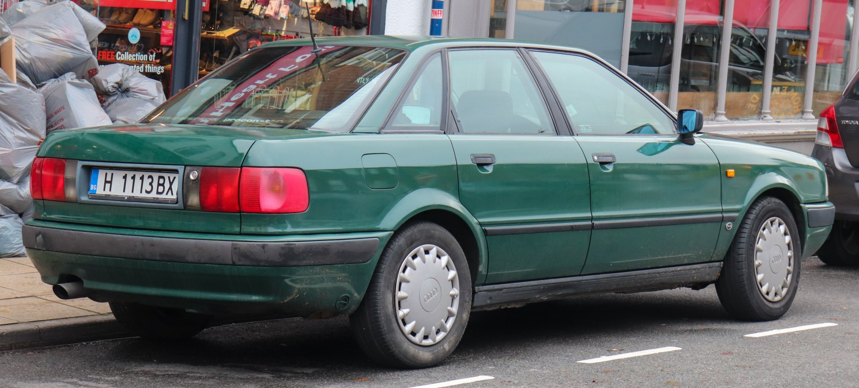 Rear and side view of classic 90s sedan with distinct tail lights and hubcaps