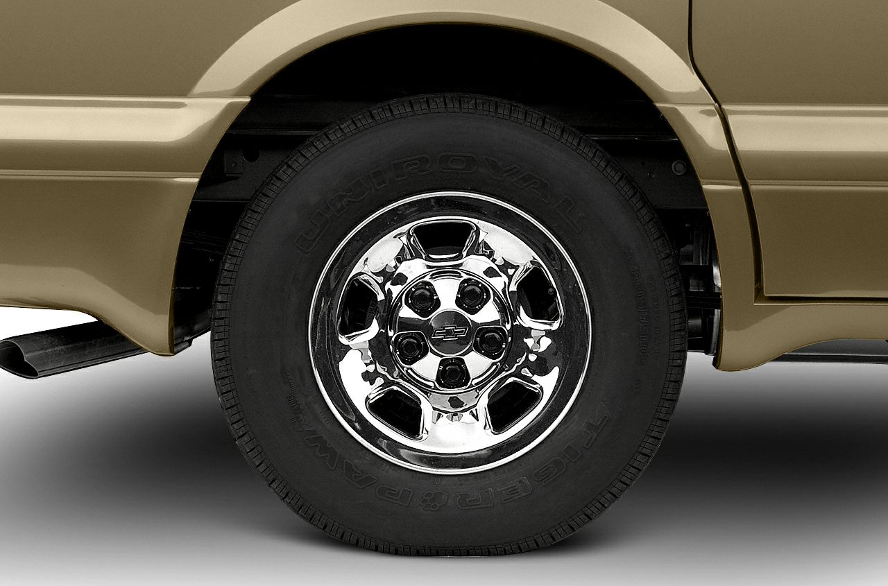 Chrome alloy wheel and tire close-up with exhaust pipe detail