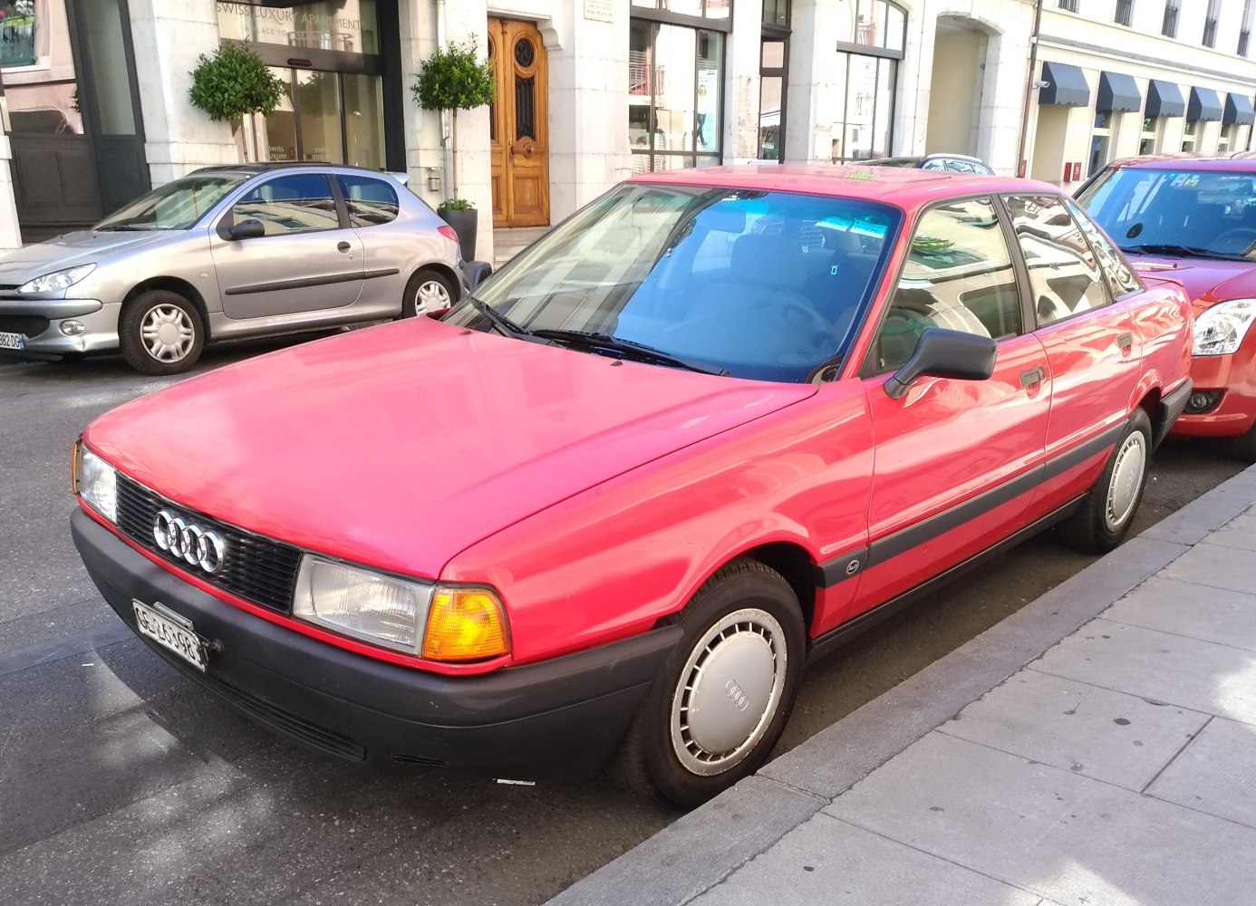 Red classic sedan with front-side view and distinct headlamps