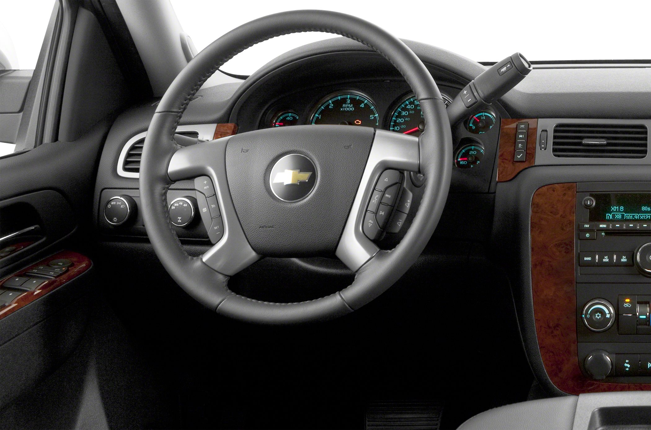 Steering wheel with control buttons and dashboard gauges with woodgrain trim