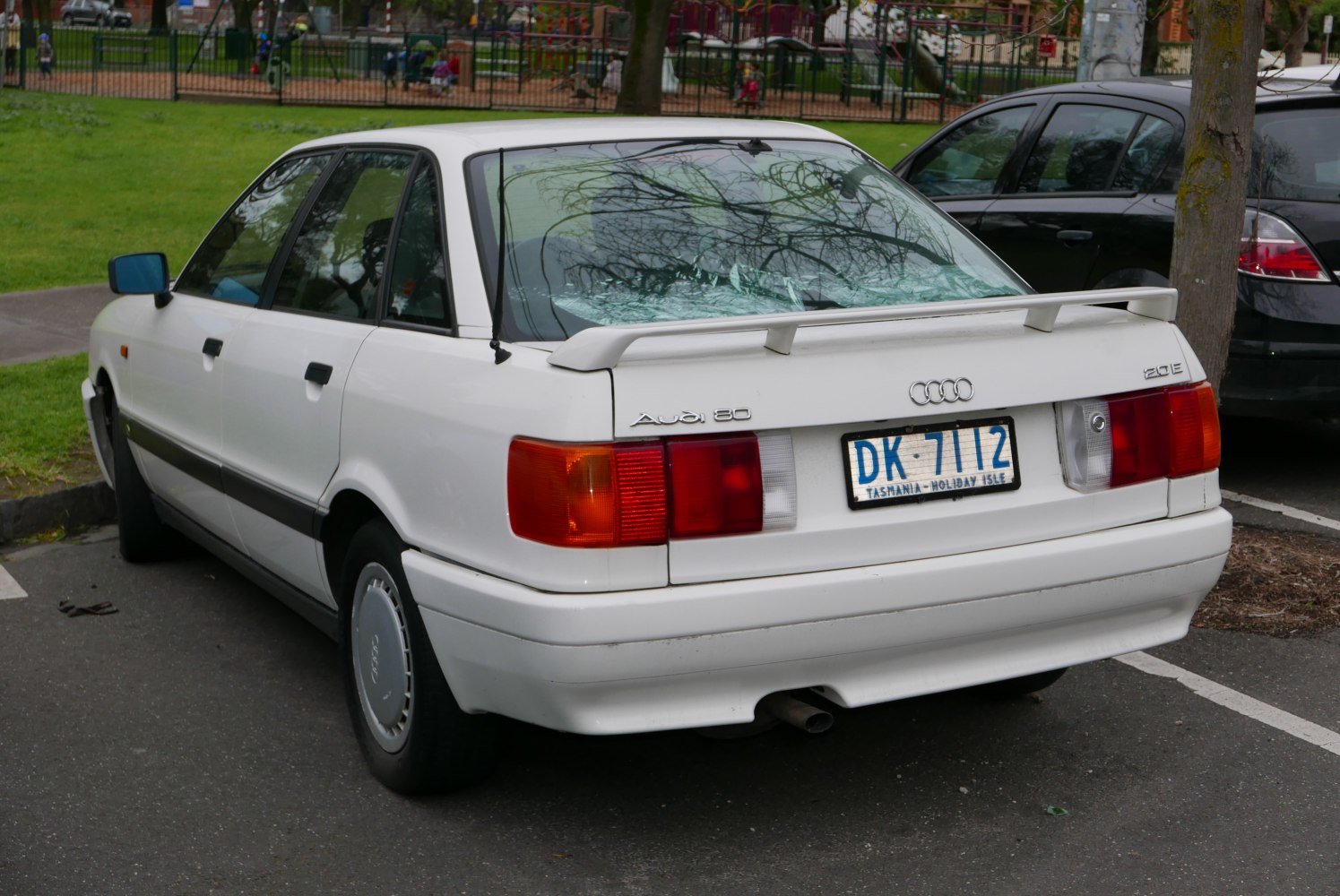 White sedan rear view with spoiler and classic taillights