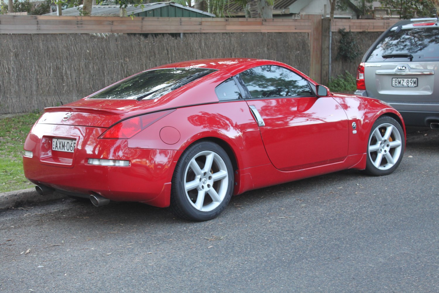 Rear side view of red sports coupe with five-spoke alloy wheels
