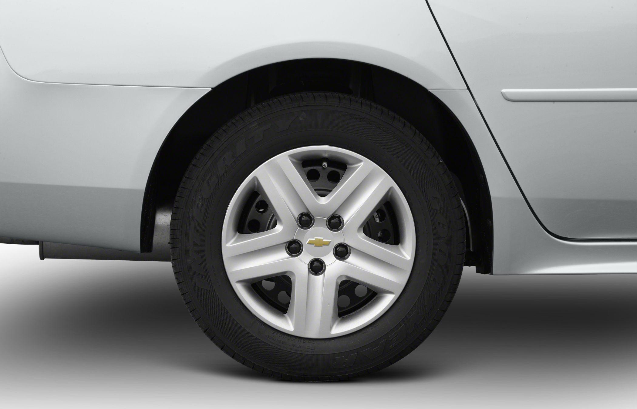 Five-spoke alloy wheel and tire closeup on a vehicle rear side