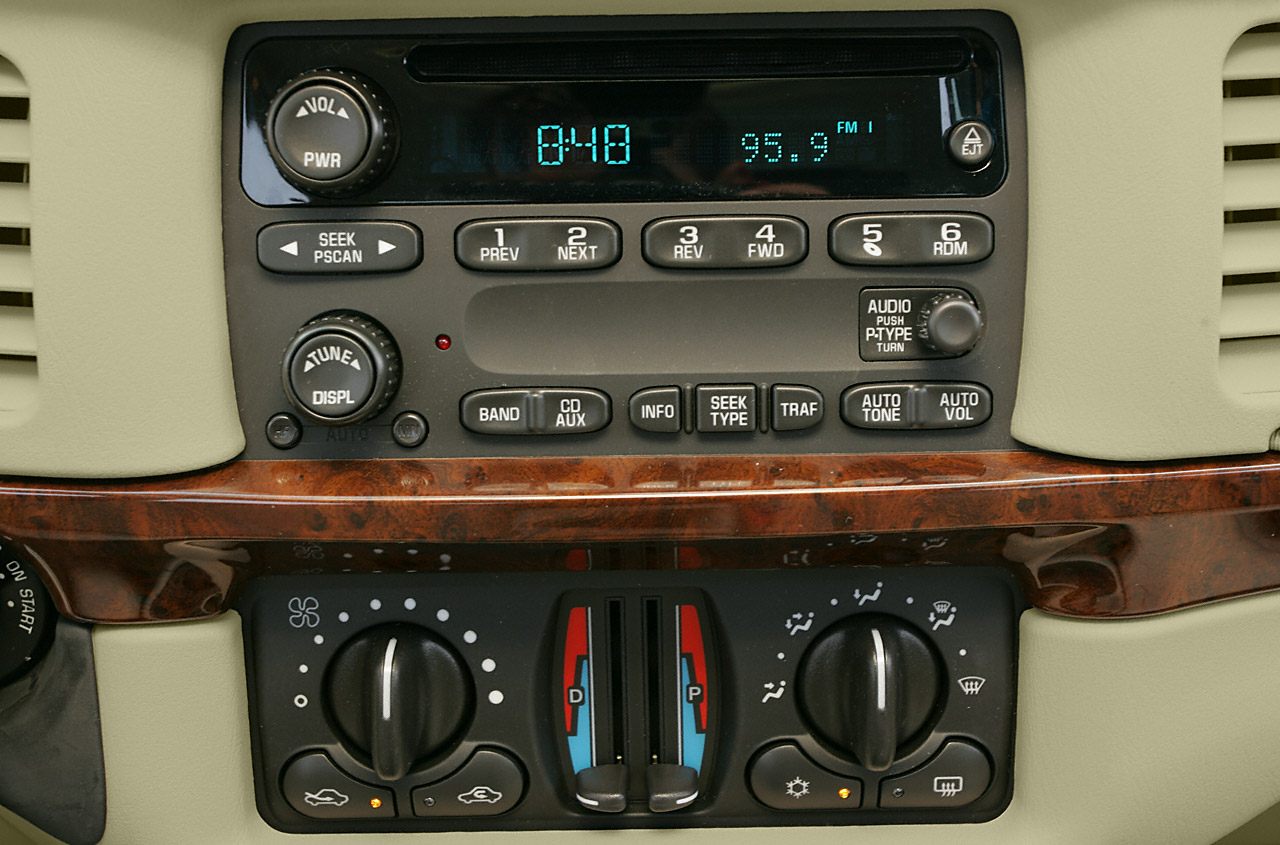 Analog car radio and climate control panel with wood trim