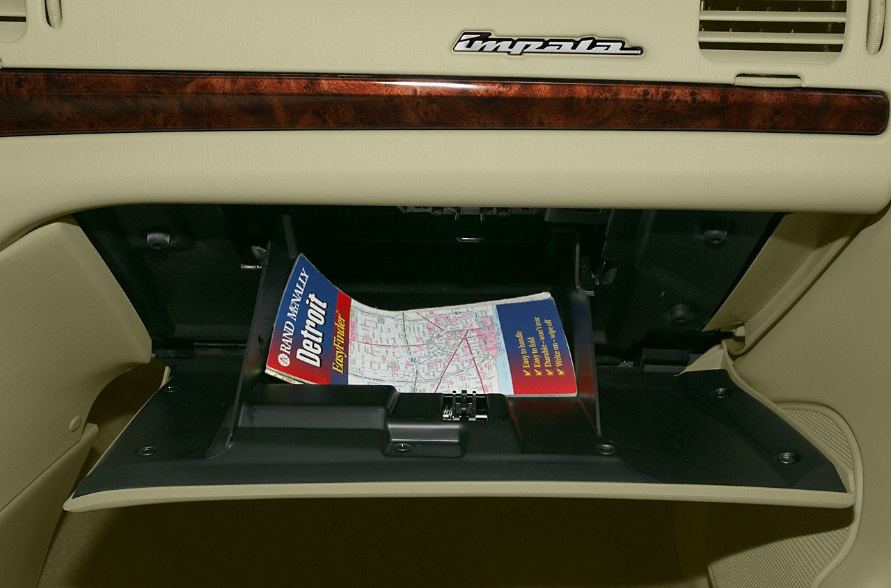 Open glove compartment with Impala emblem and wood trim