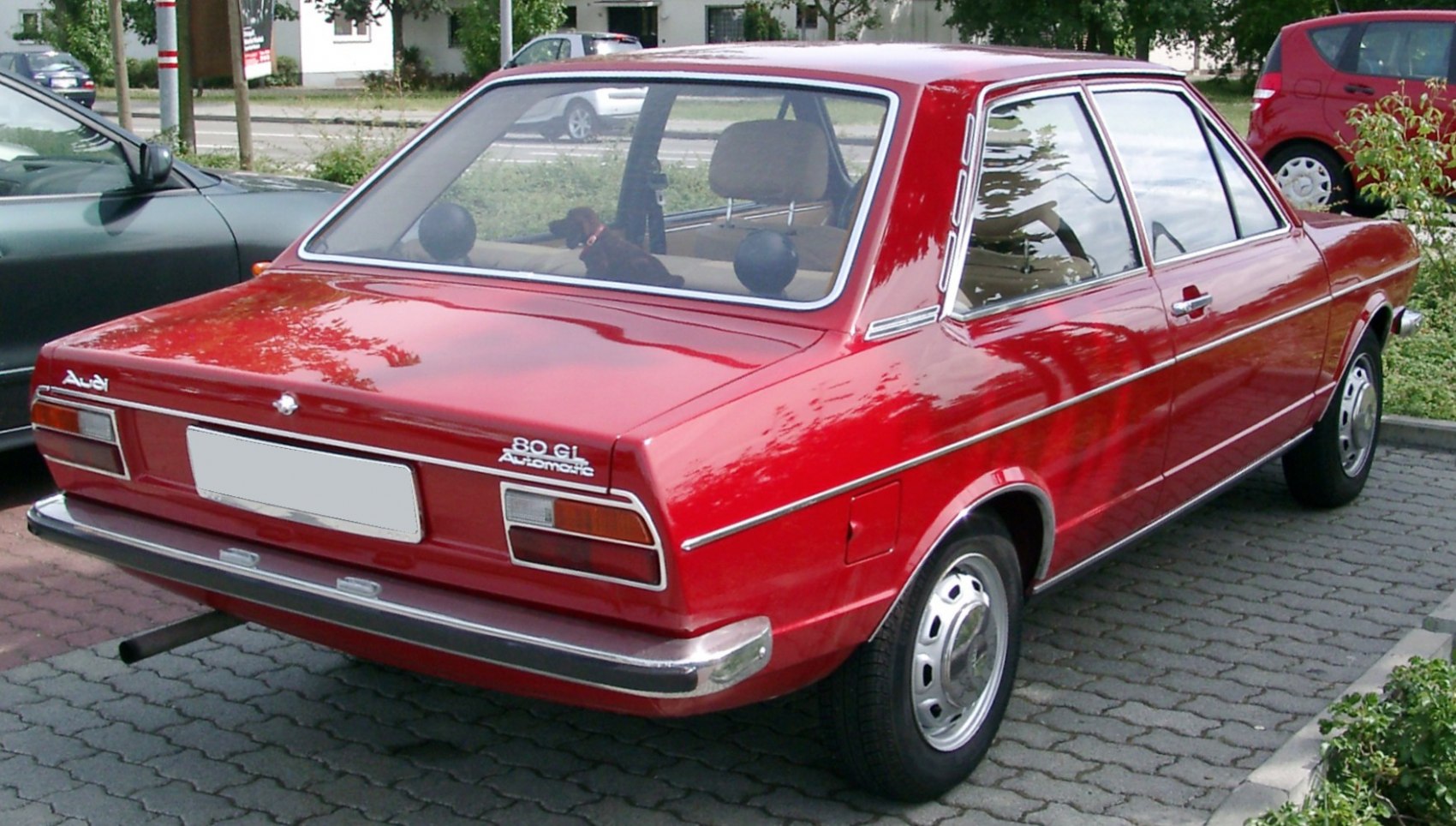 Rear view of vintage red sedan with chrome bumper and rectangular taillights