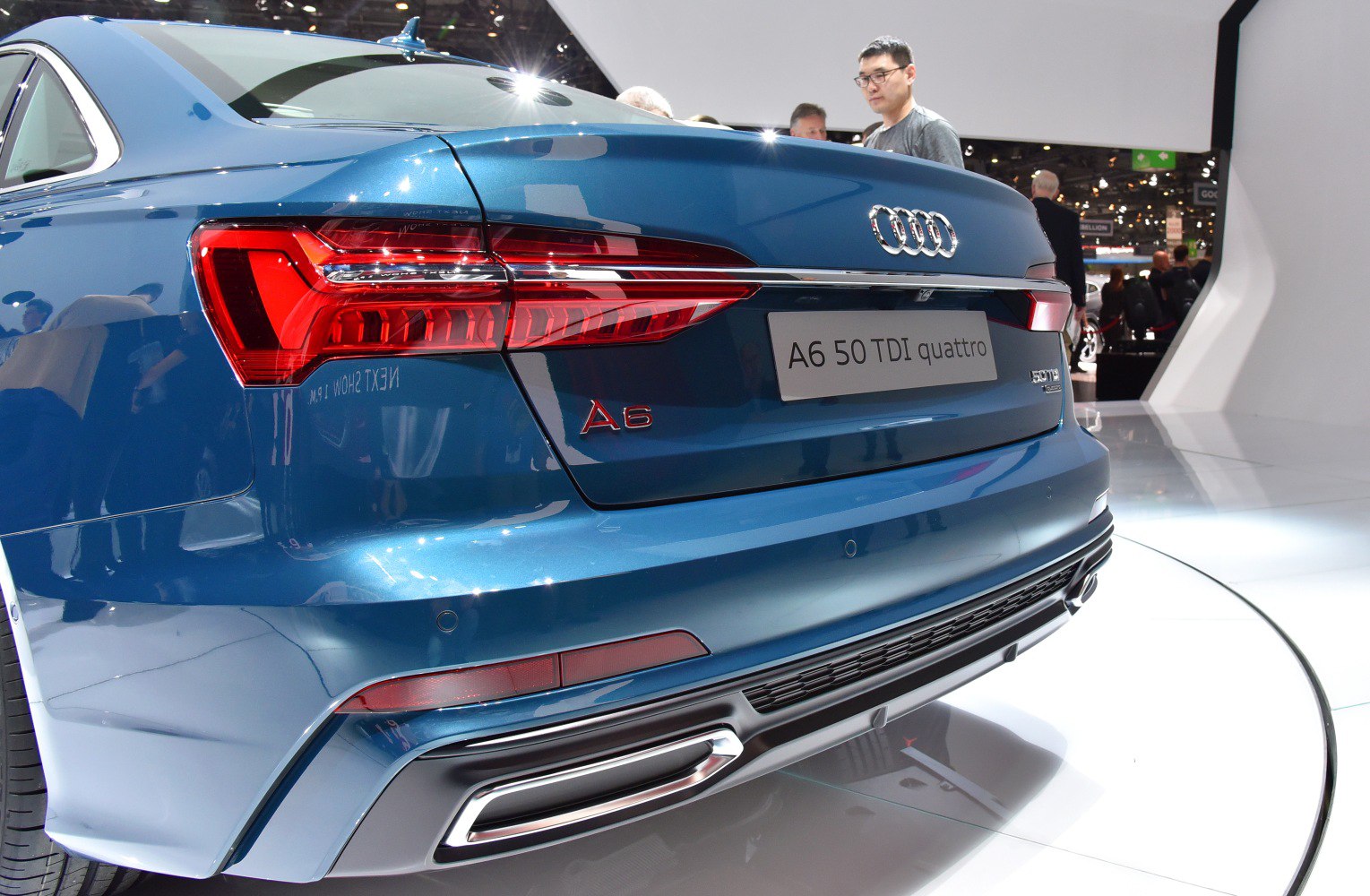 Rear LED taillights and sporty exhaust on a blue sedan