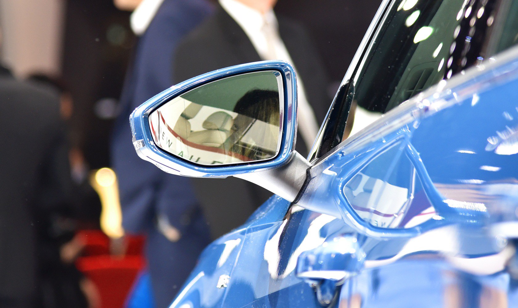 Close-up of side mirror and door handle with reflective surface