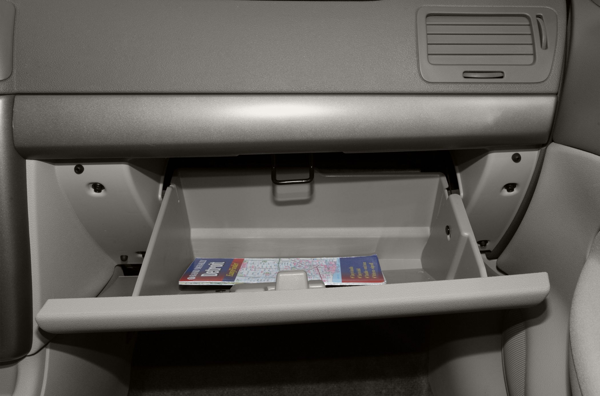 Open glove compartment with map inside in car interior