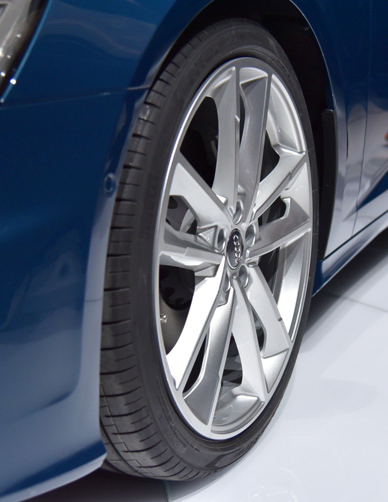 Silver alloy wheel with five dual-spoke design on luxury sedan.