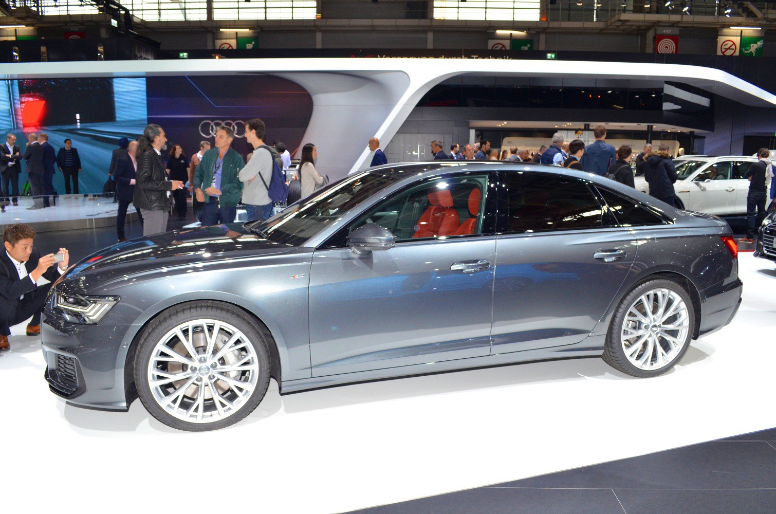 Side profile of a luxury sedan with red leather interior and alloy wheels