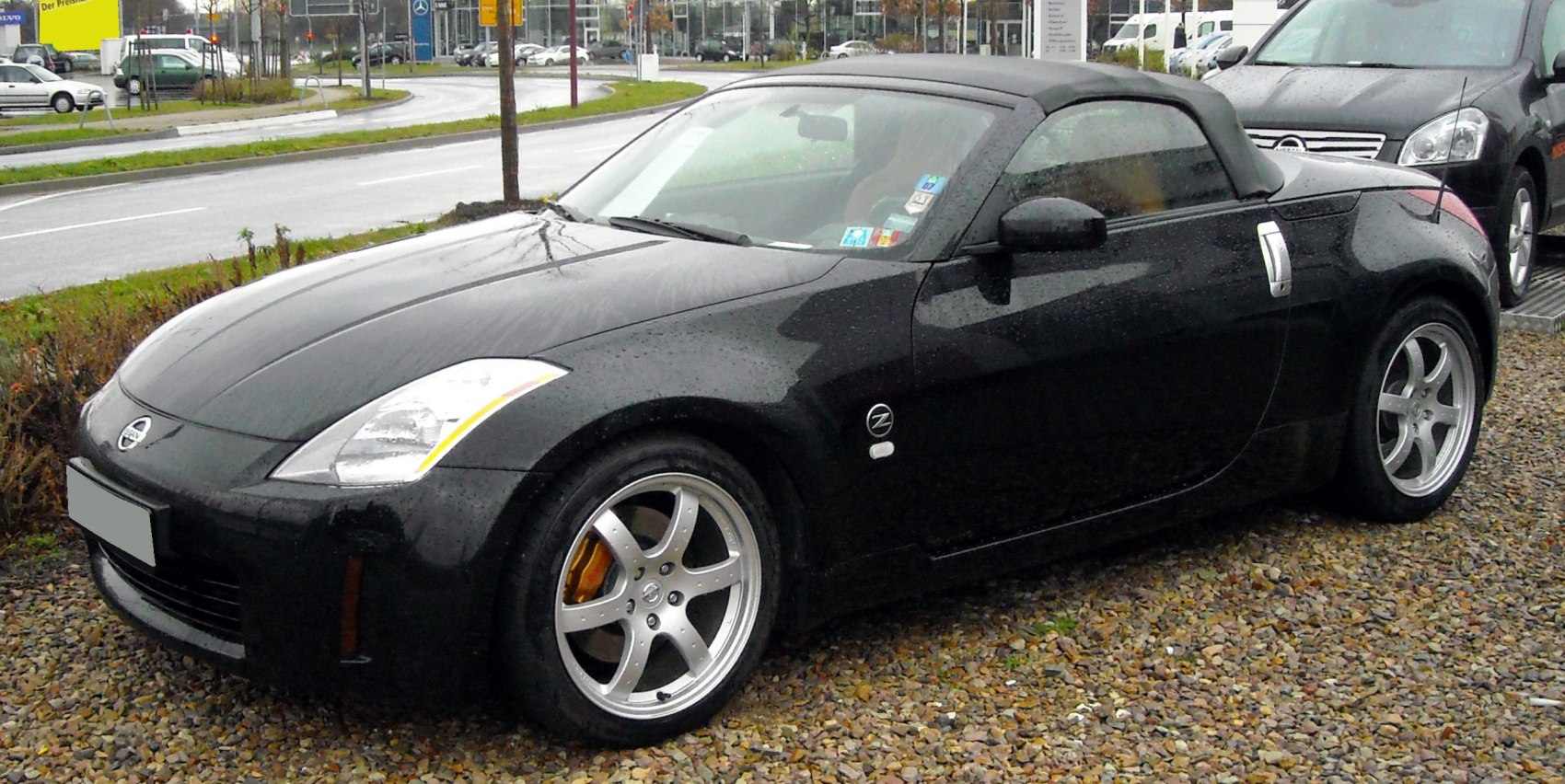 Black convertible roadster with five-spoke alloy wheels and soft top
