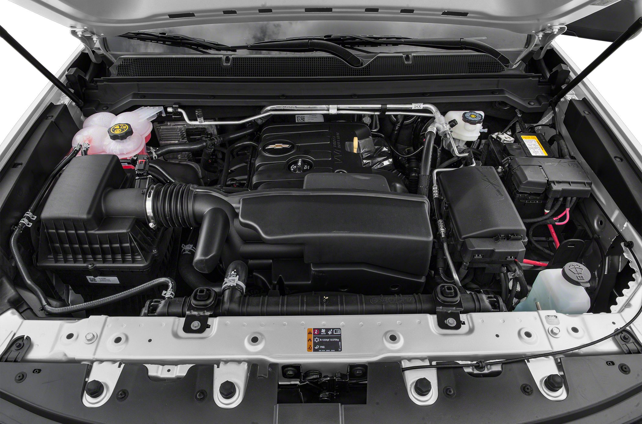 Engine bay with visible air intake, coolant reservoir, battery, and fluid reservoirs under open hood.