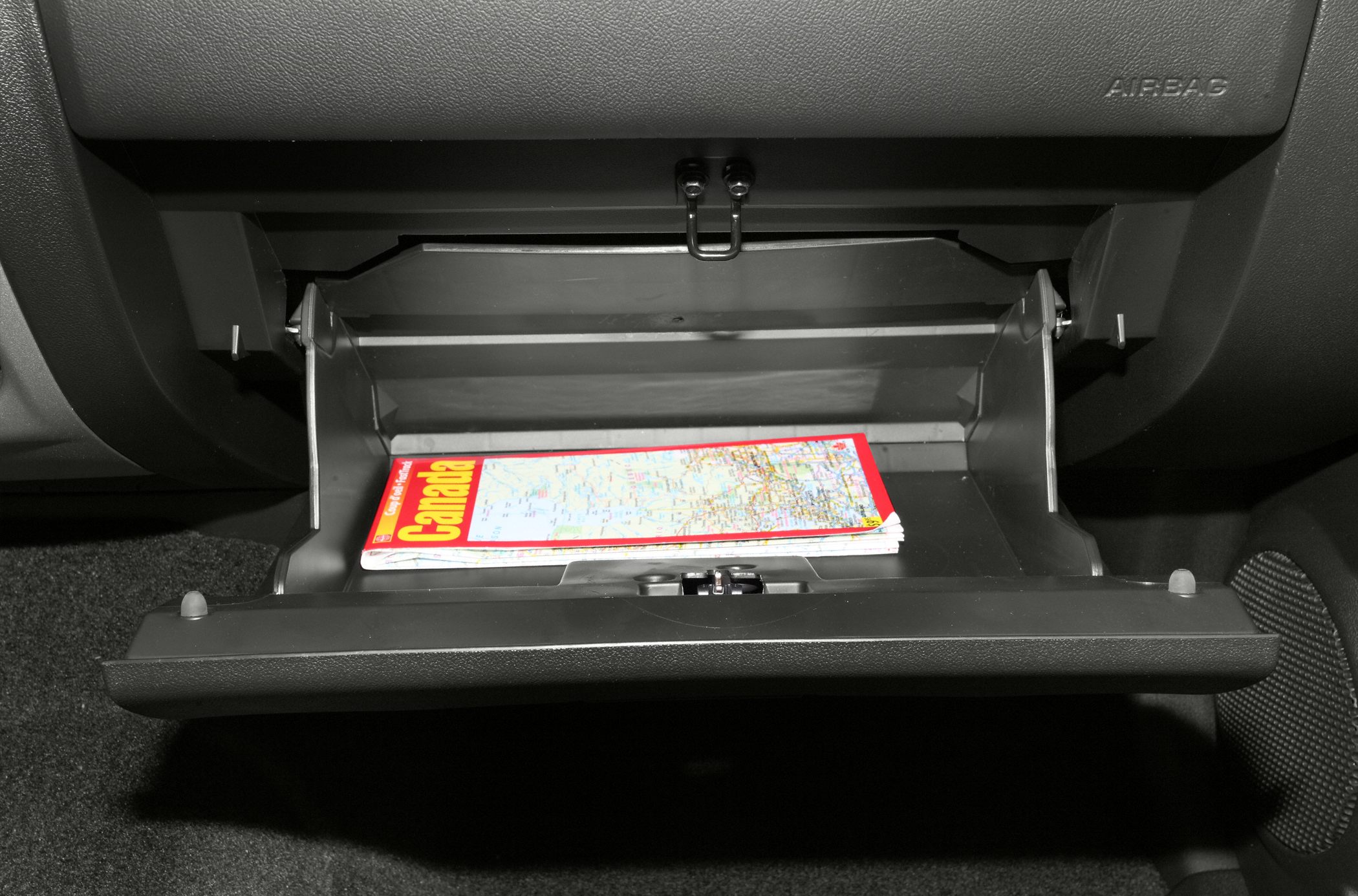 Open glove compartment with storage space and a map inside