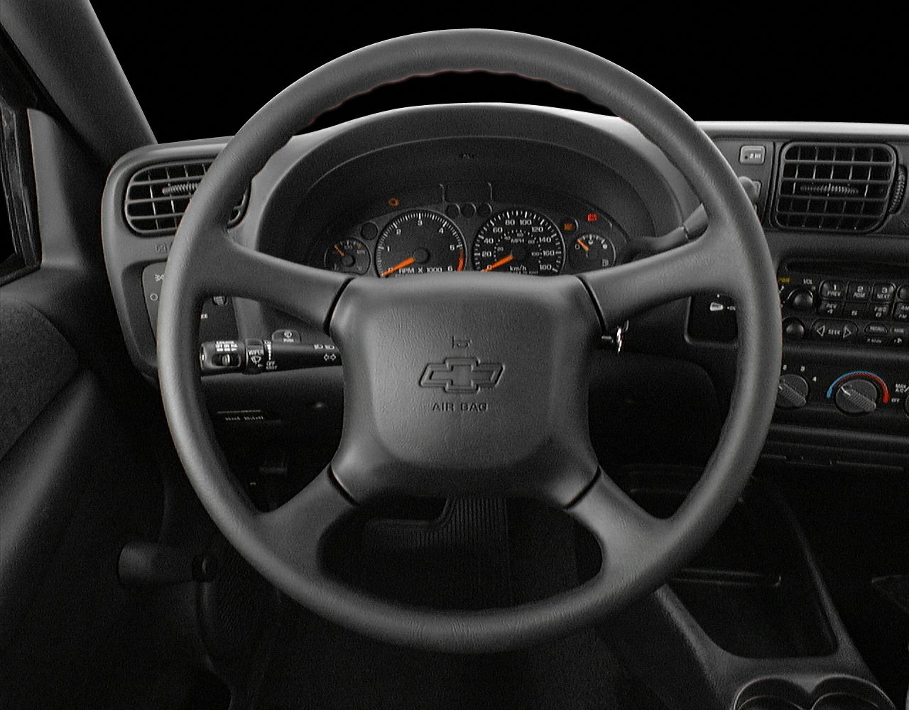 Steering wheel and dashboard with gauges and controls in a vehicle interior