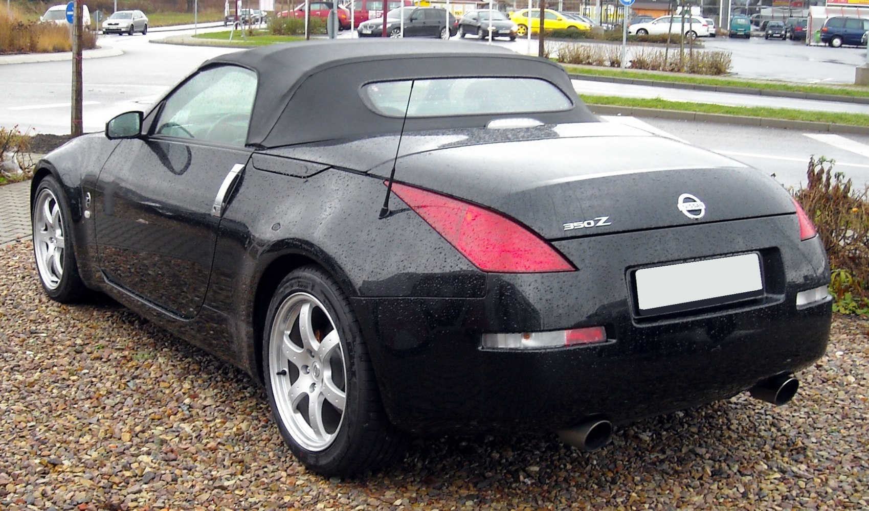 Rear view of a black convertible with soft top, sporty design, and distinct taillights