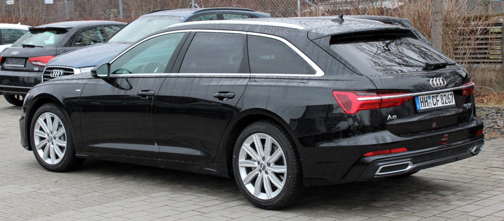 Rear side view of a black luxury wagon with alloy wheels and distinctive rear light design