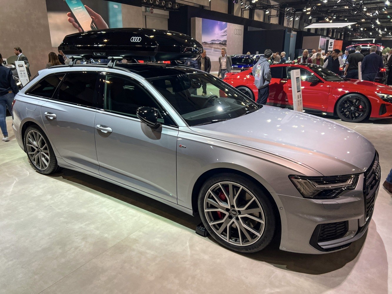 Silver station wagon with roof cargo box and alloy wheels at car show