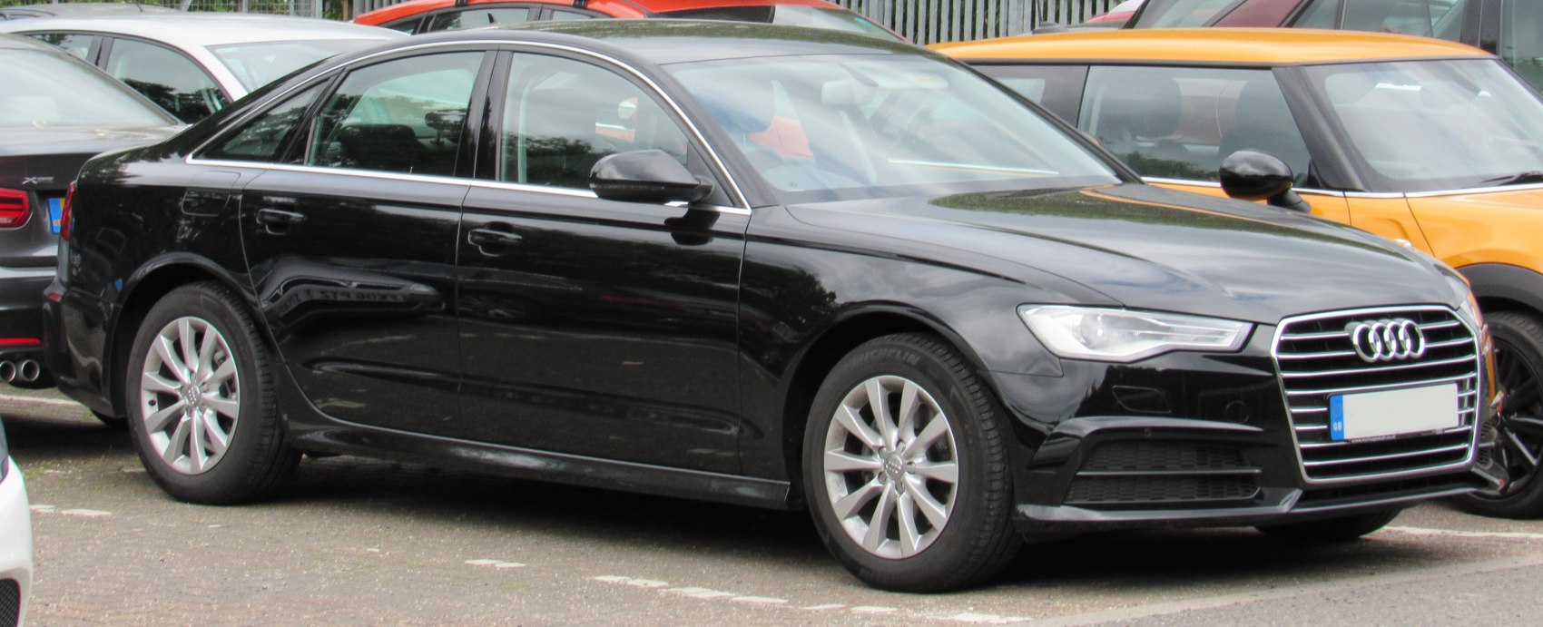 Black sedan with distinctive grille and LED headlights, front side view