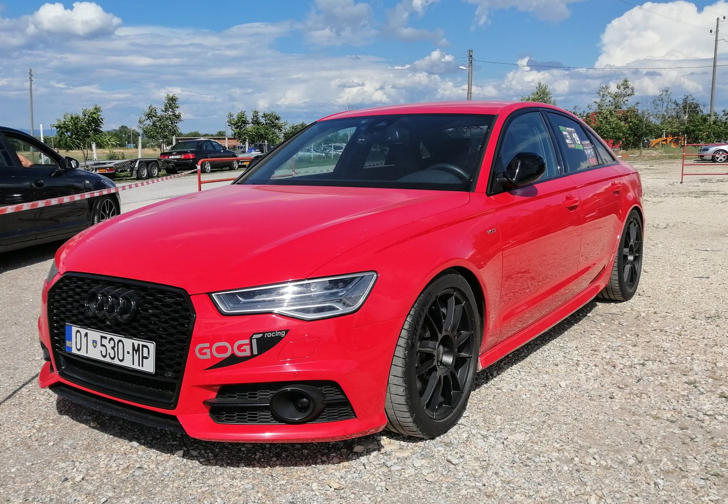 Red sporty sedan with black wheels and signature front grille