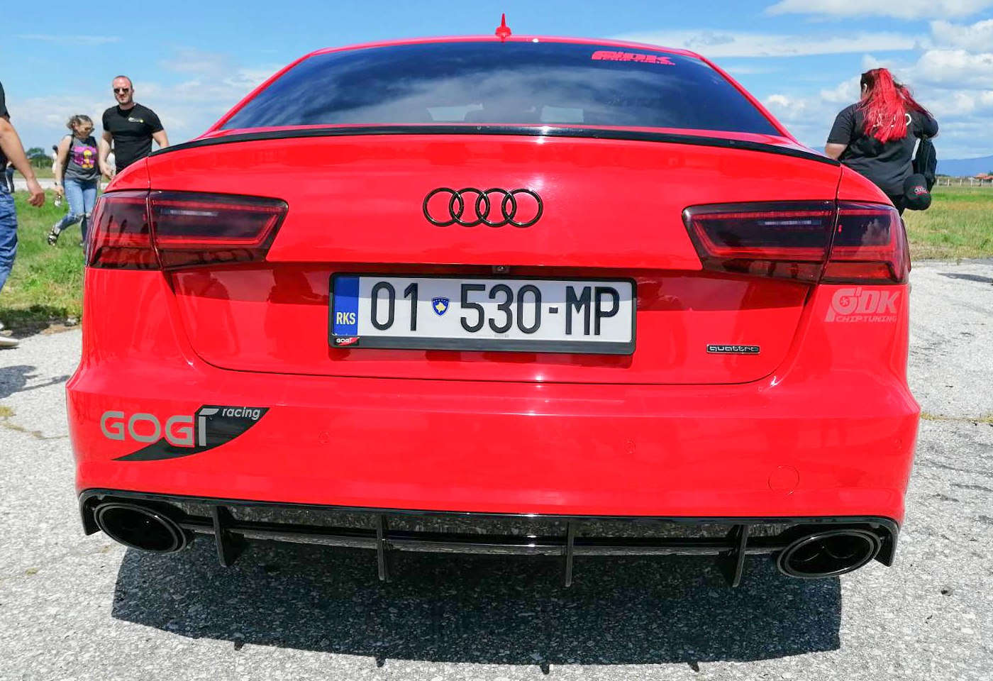 Rear view of red sedan with dual exhaust and tinted taillights